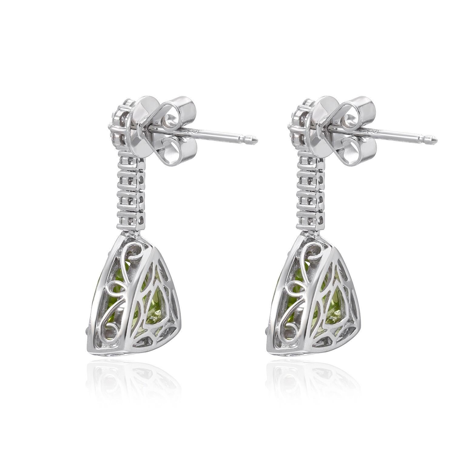 Peridot pair of trillions, weighing a total of 4.23 carats, adorned by round brilliant diamonds weighing a total of 0.77 carats, to comprise this fantastic pair of drop 18K white gold earrings for women.

0.75 inches in length.

Returns are accepted