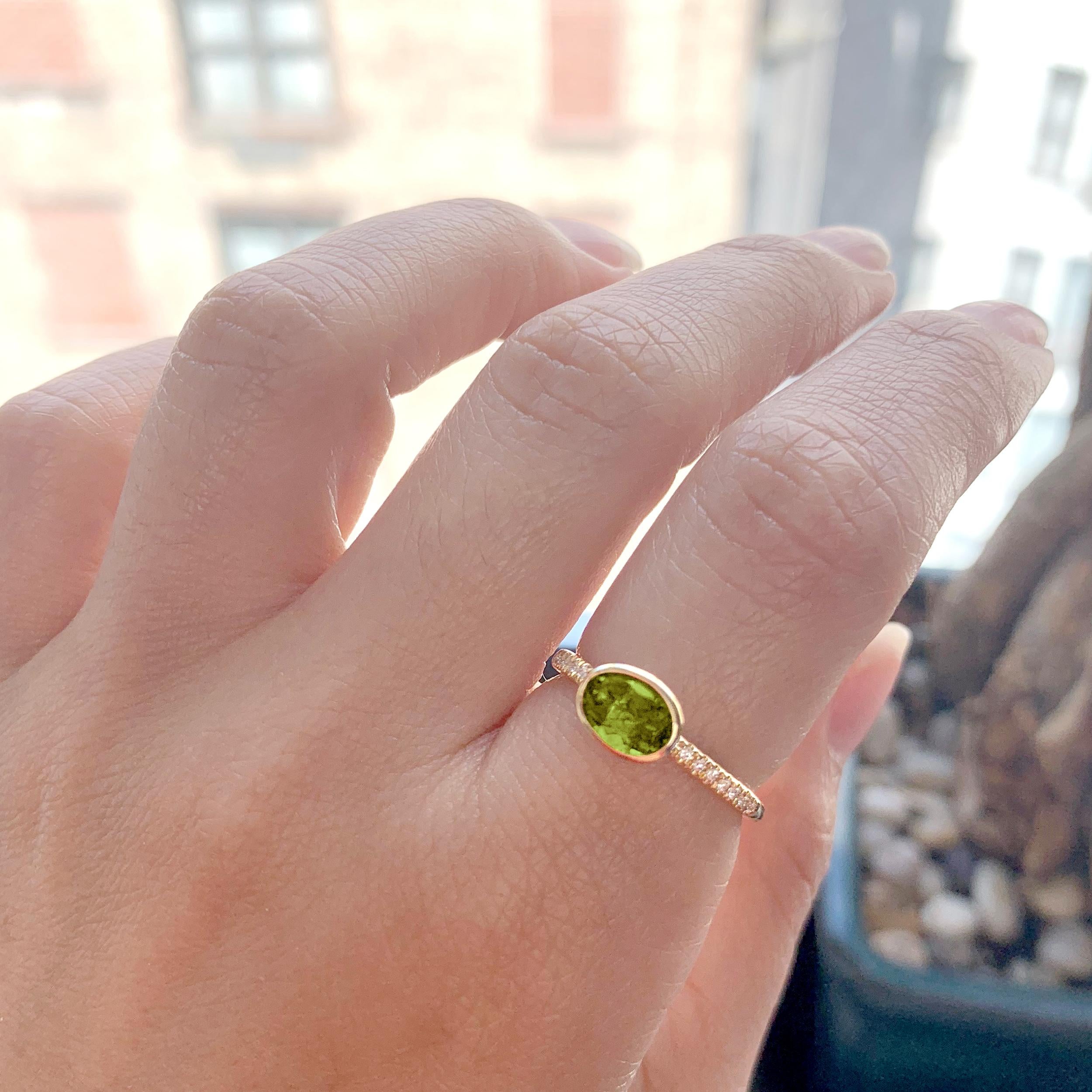 Cette bague étonnante met en valeur un péridot ovale à facettes en son centre, rayonnant d'une énergie fraîche et lumineuse. Sertie dans de l'or jaune 18 carats, la teinte verte vibrante de la pierre précieuse est magnifiquement rehaussée par