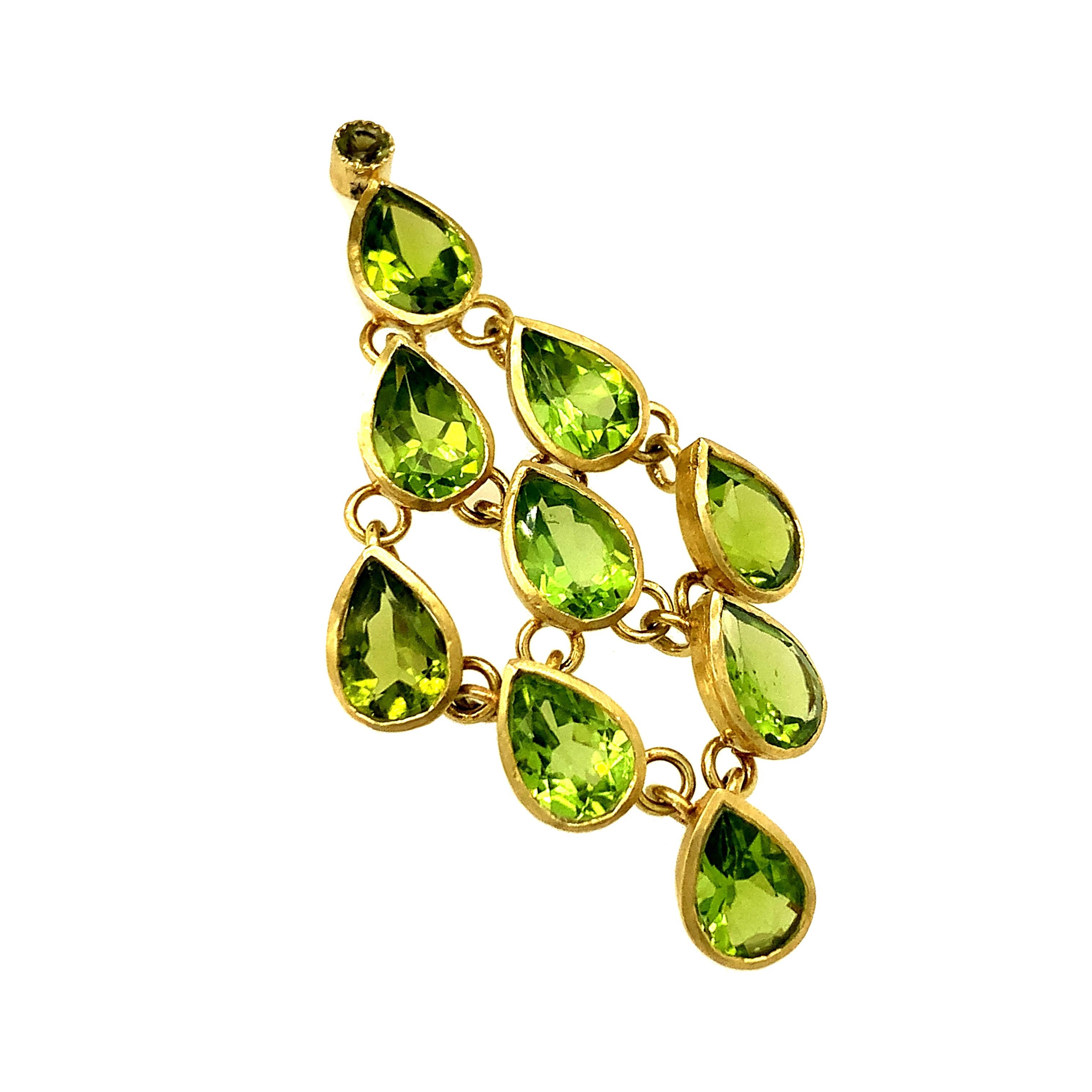 A dazzling pair of Chandelier earrings. Cascading down the ear, each tier features a bezel-set pear-shaped peridot set in 18k yellow gold.  Captures light beautifully with movement.  Approximately 2 1/4