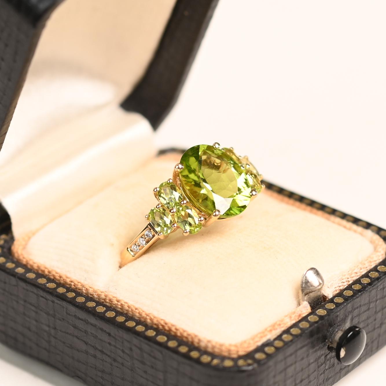 Questo squisito anello con diamante in oro e peridoto mette in mostra un affascinante peridoto di circa 3,40 carati al centro, che irradia una vibrante tonalità verde. Per esaltare la sua brillantezza, altre tre pietre di peridoto dal taglio ovale