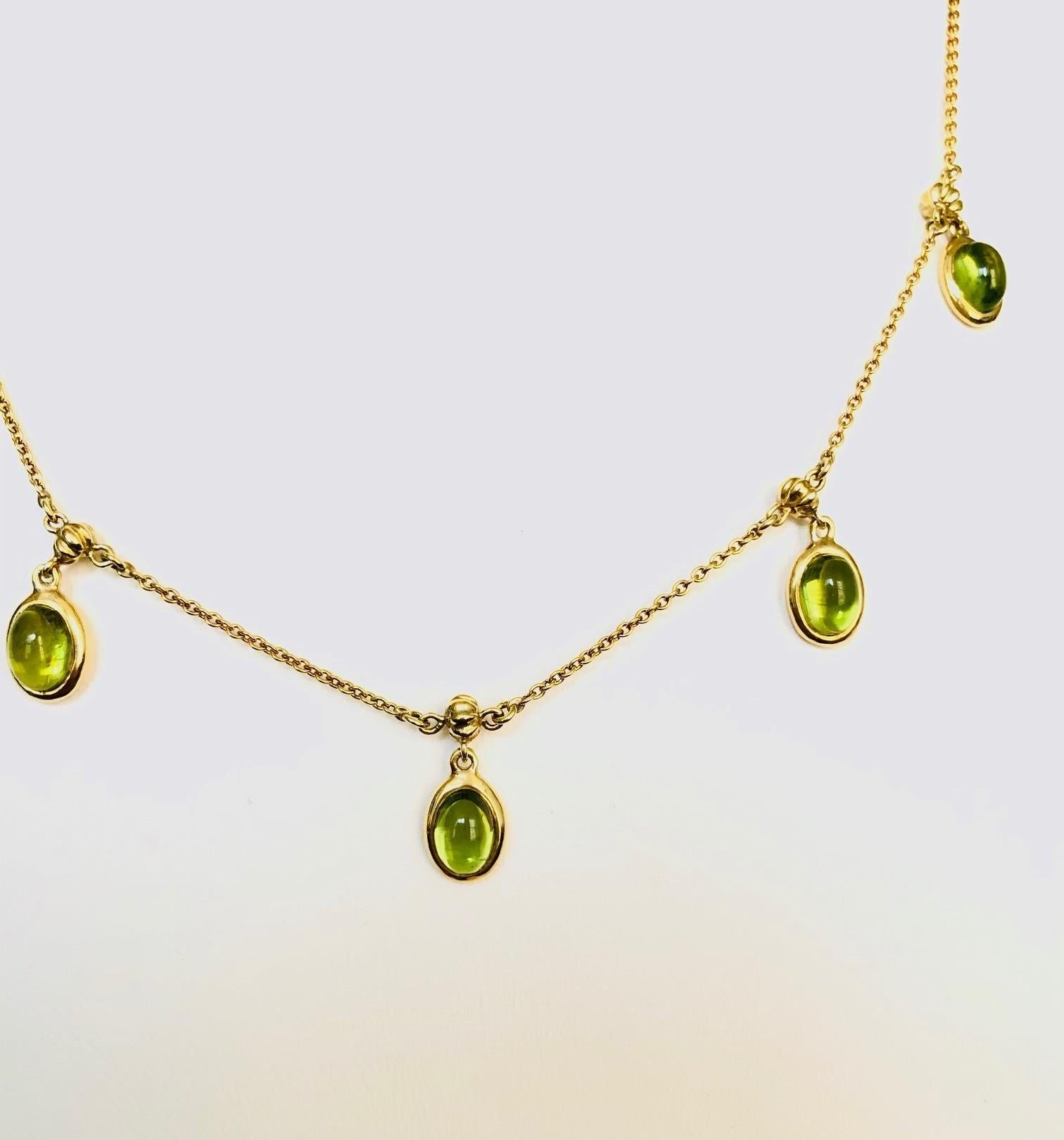 Modern, Necklace with dangling color stones, made in 18 Kt Yellow Gold, set with 5 Oval Cabochon Peridots 6.30 carats.
Available in many colors.

We manufacture all of our jewelry, in our workshop located in New York City's diamond district.