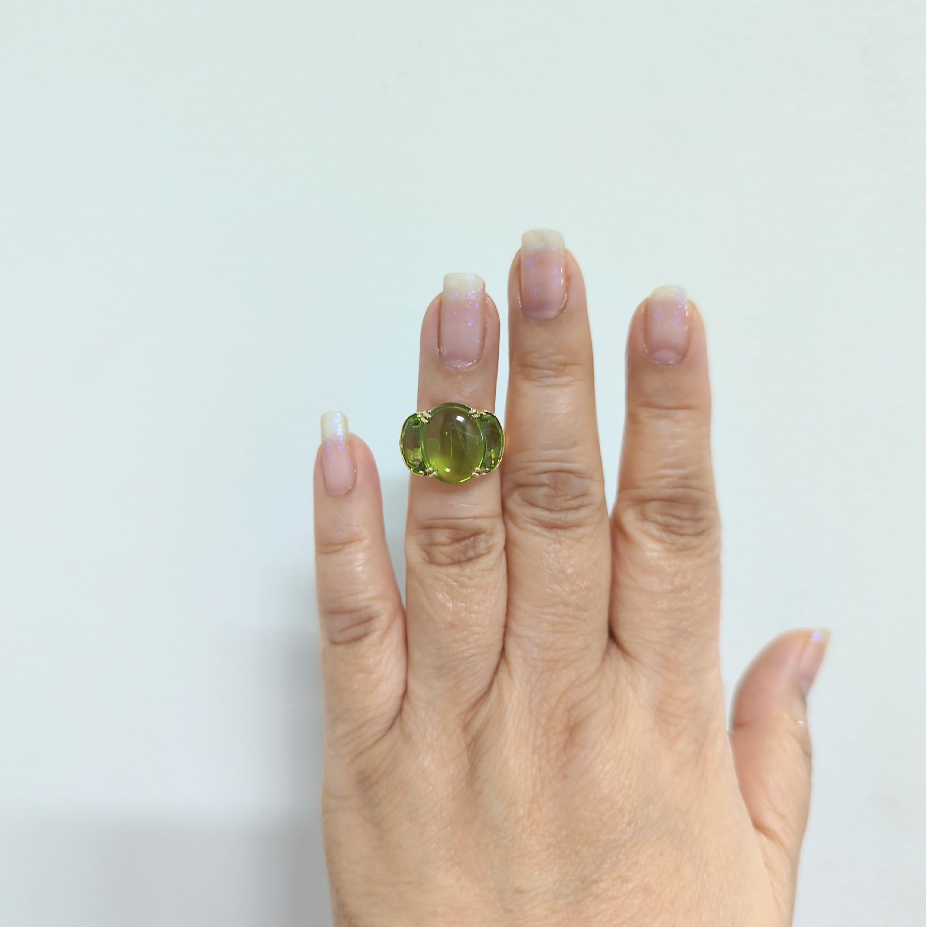 Beautiful three stone cocktail ring with a bright green peridot cabochon oval and two half moon cabochon side stones.  Handmade in 18k yellow gold.  Ring size 4.75.