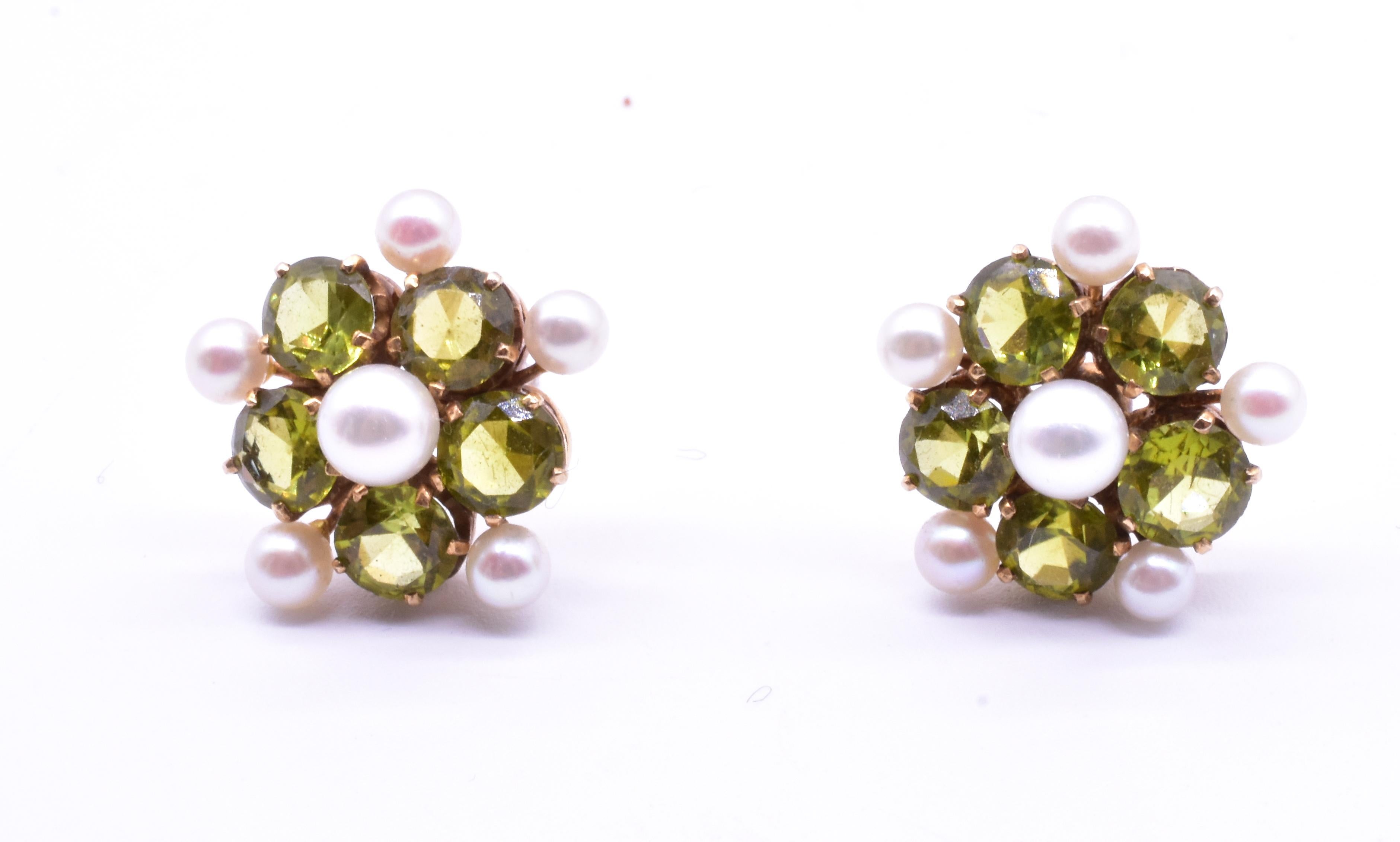 Cute pair of open backed 14K peridot and pearl earrings set in a double forget-me-not arrangement,  with 5 pearls radiating around on the outside border in a forget me-not-pattern (and a larger pearl at the center) and 5 peridots revolving on the