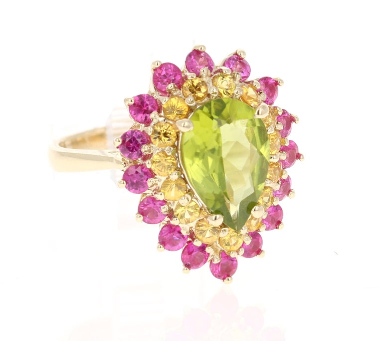 This beautiful ring has a Pear Cut Peridot in the center that weighs 2.46 carats. The first halo is of 15 Yellow Sapphires that weigh 0.86 carats and the second halo is of Pink Sapphires that weigh 1.36 carats. The total carat weight of the ring is