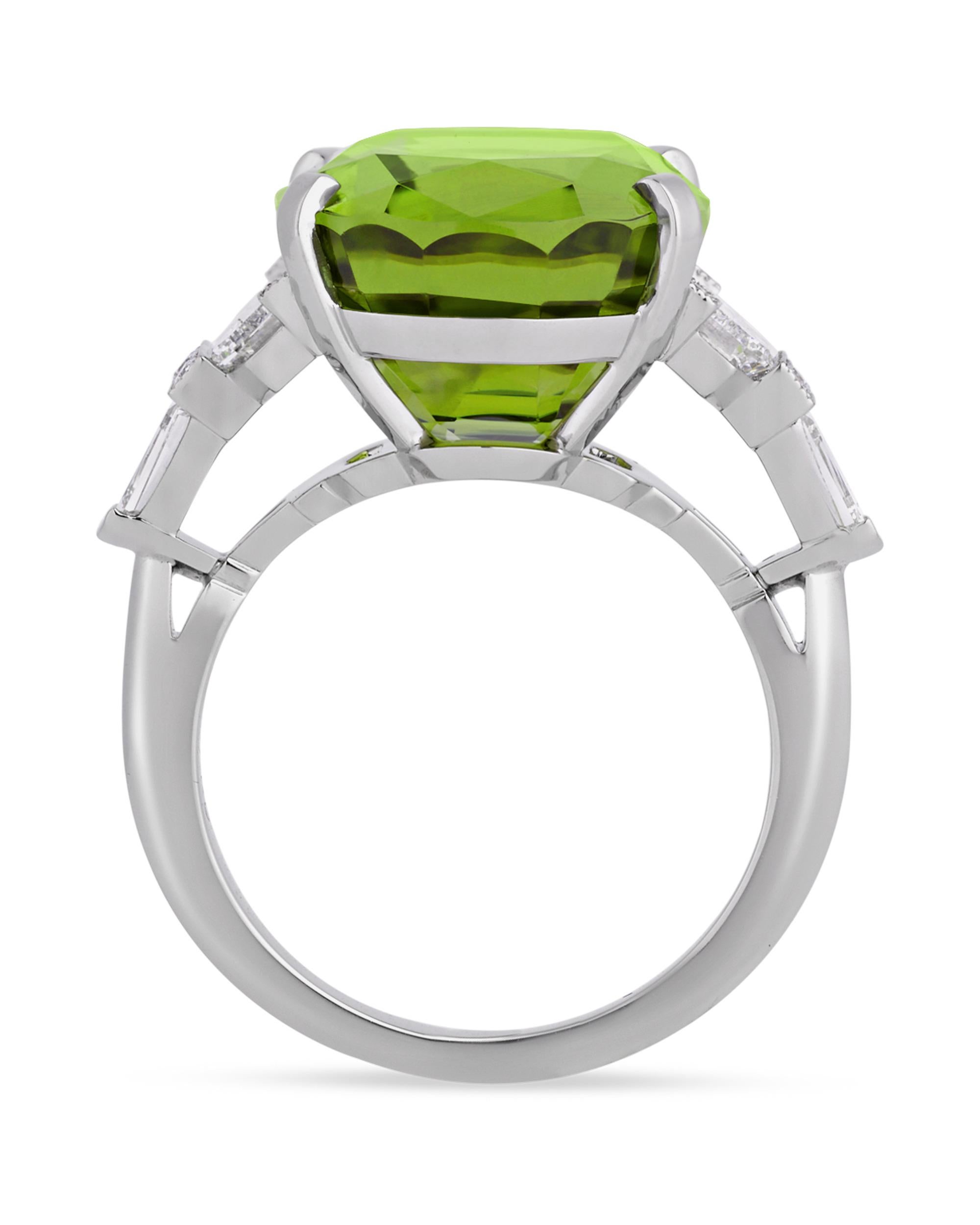 A lush 15.36-carat peridot showcases its unmistakable green hue in this ring from celebrated jeweler Raymond Yard. This brilliant jewel is joined by a myriad of baguette, tapered-bullet and round-cut white diamonds totaling 1.42 carats in its