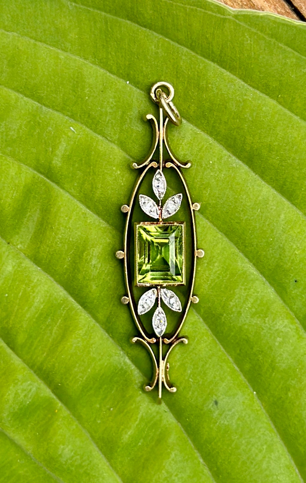 Este es un impresionante collar colgante victoriano - eduardiano de peridoto y diamantes talla rosa en platino sobre oro de 14 quilates.  El lavaliere está centrado por un precioso peridoto talla esmeralda de 2 quilates.  El color de esta gema es