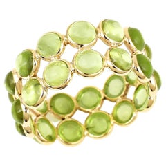 Fascia a doppia linea con cabochon rotondo di peridoto, oro giallo