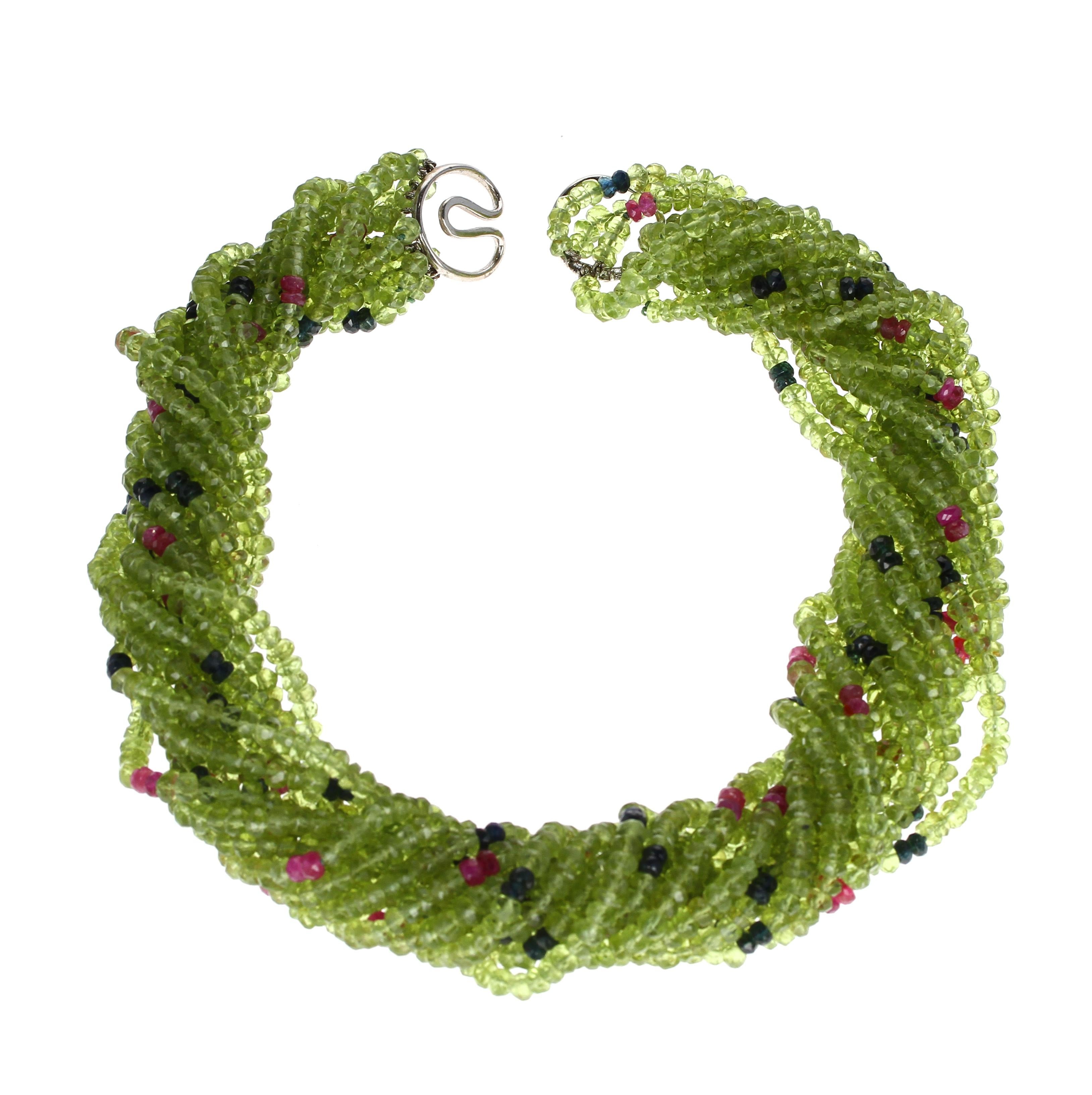 A unique yet chic peridot bead necklace studded with ruby and blue sapphire beads, set with an 18kt white gold clasp; the total weight of the necklace is approximately 986 carats; the length is 17 inches.