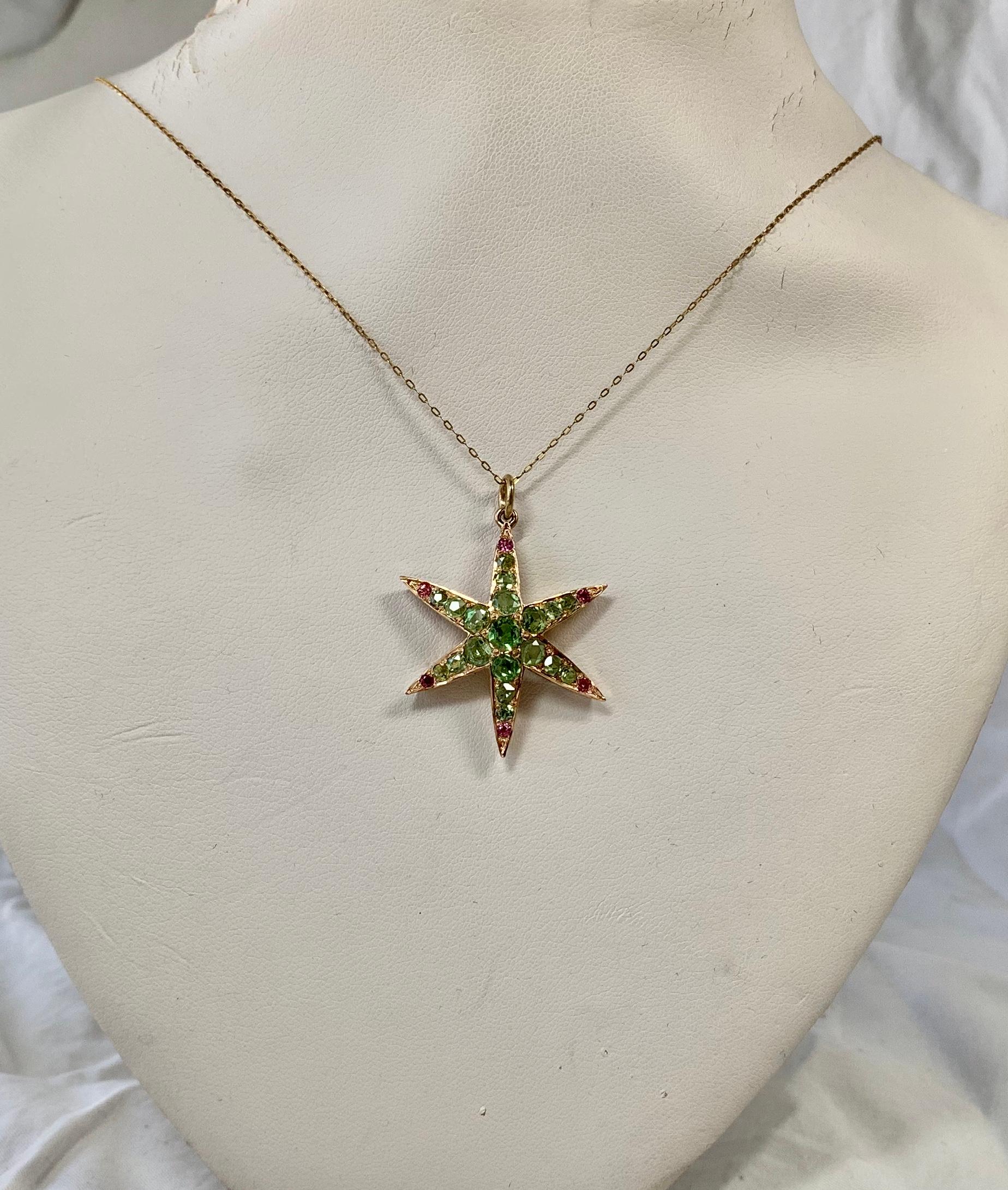 This is a stunning antique Victorian - Edwardian Peridot and Ruby Star Starfish Lavaliere Pendant Necklace in 14 Karat Gold.  The gorgeous star motif pendant is set with 19 sparkling round faceted graduated Peridot gems.  At each of the six ends of