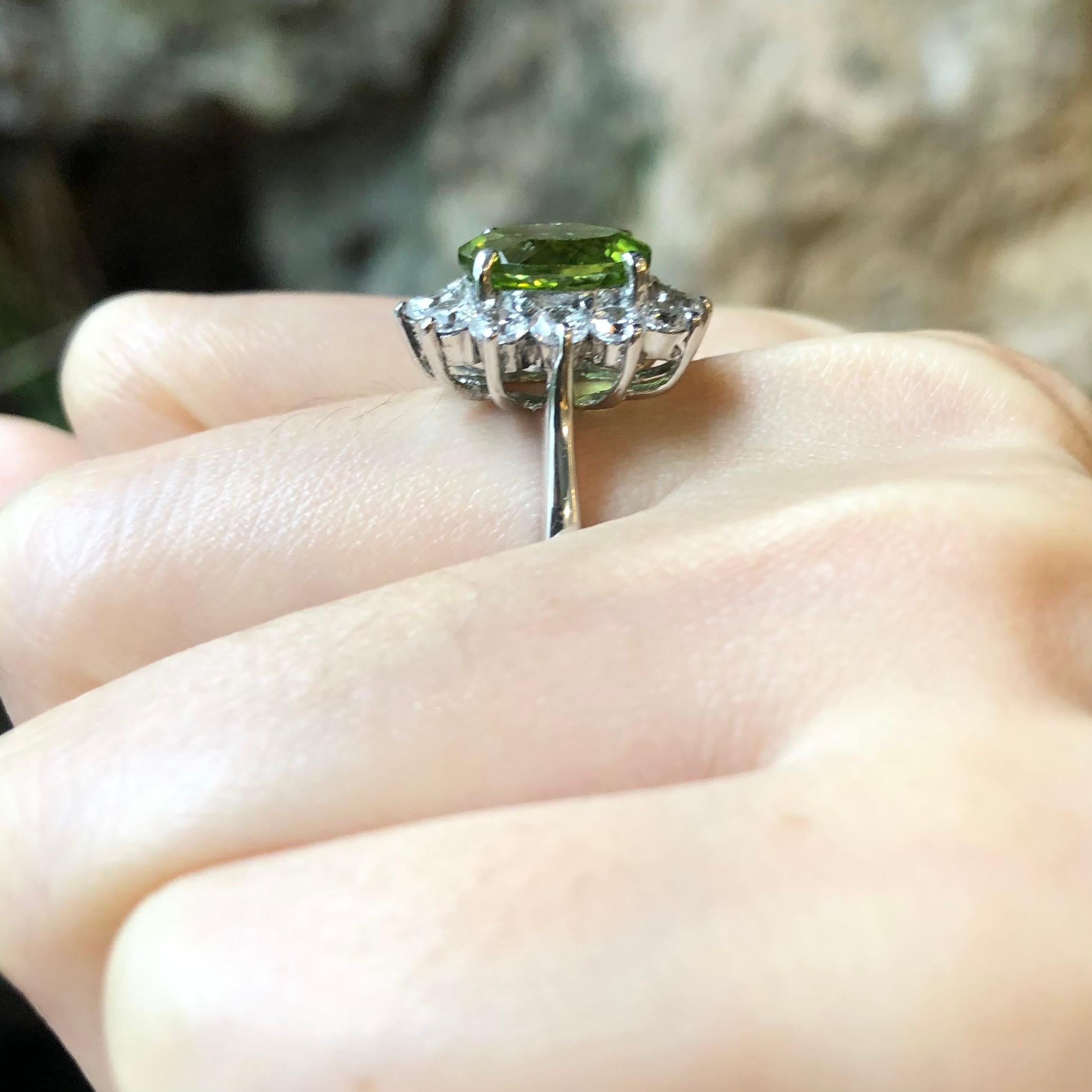 Peridot with Cubic Zirconia Ring set in Silver Settings

Width:  1.3 cm 
Length: 1.8 cm
Ring Size: 56
Total Weight: 6.09 grams

*Please note that the silver setting is plated with rhodium to promote shine and help prevent oxidation.  However, with