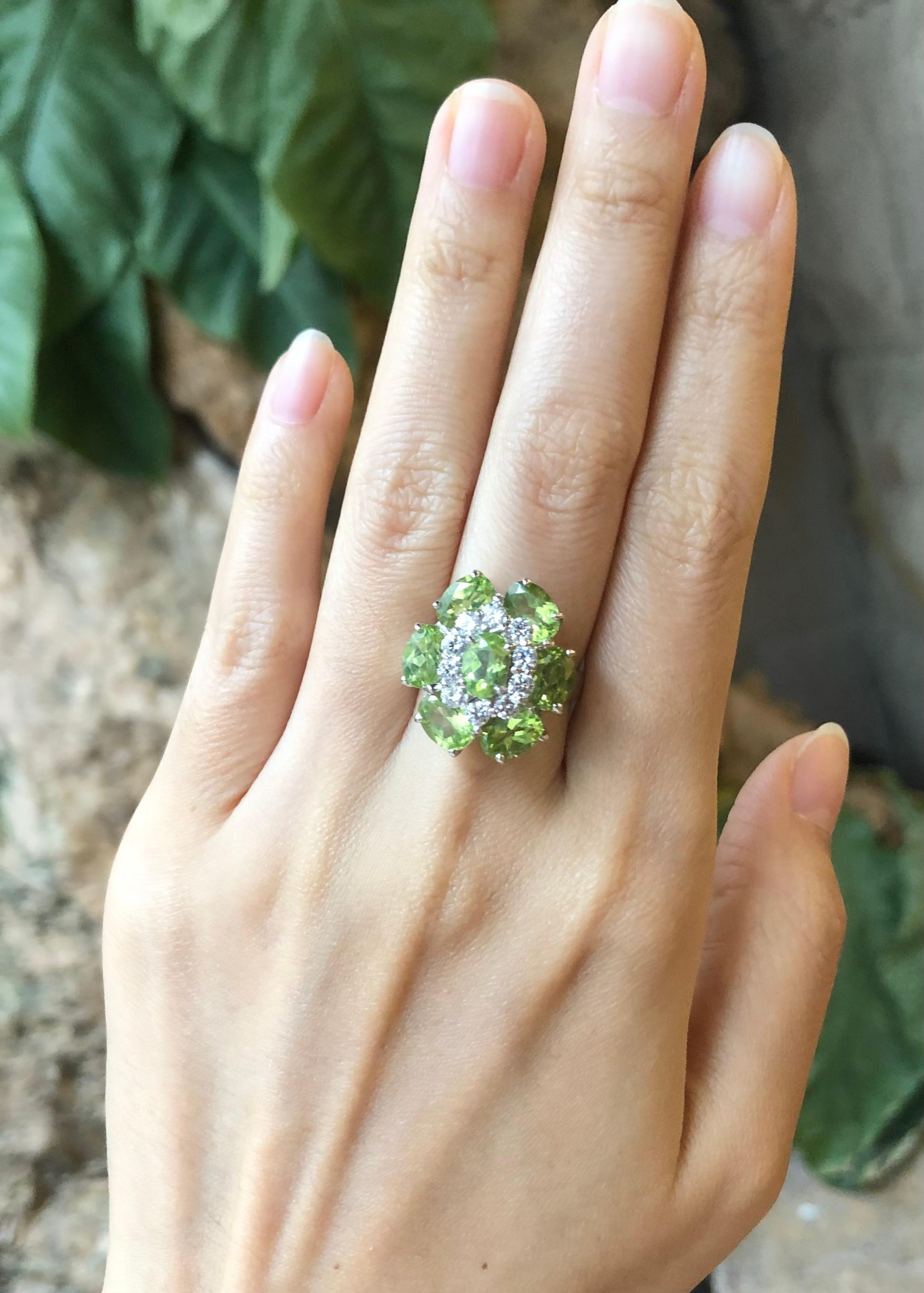 Peridot with Cubic Zirconia Ring set in Silver Settings

Width:  1.9 cm 
Length: 2.1 cm
Ring Size: 54
Total Weight: 8.53 grams

*Please note that the silver setting is plated with rhodium to promote shine and help prevent oxidation.  However, with