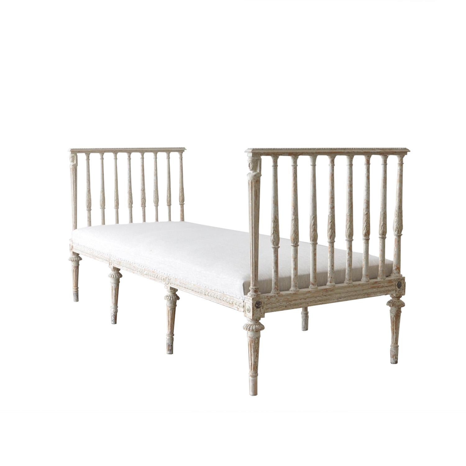 A period 18th century Gustavian day bed with carved wood and plaster decoration, scraped to original pale paint and new upholstery in linen. Circa 1780
