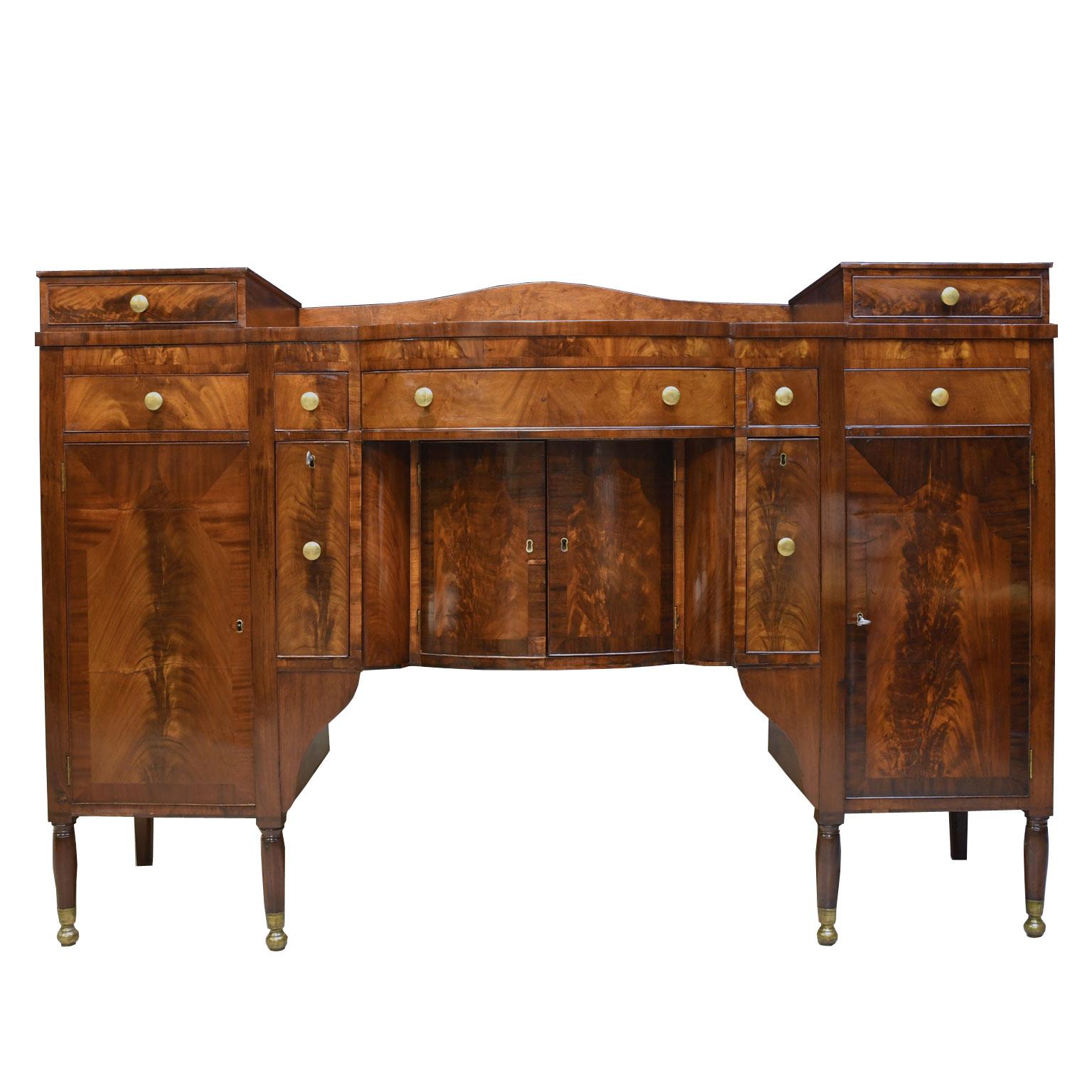 An exceptional American Sheraton Sideboard in flat cut and crotch cut mahogany veneers over a secondary wood of pine and poplar. Beautifully restored in our workshop with original finish that has been amalgamated and gently refurbished with a light