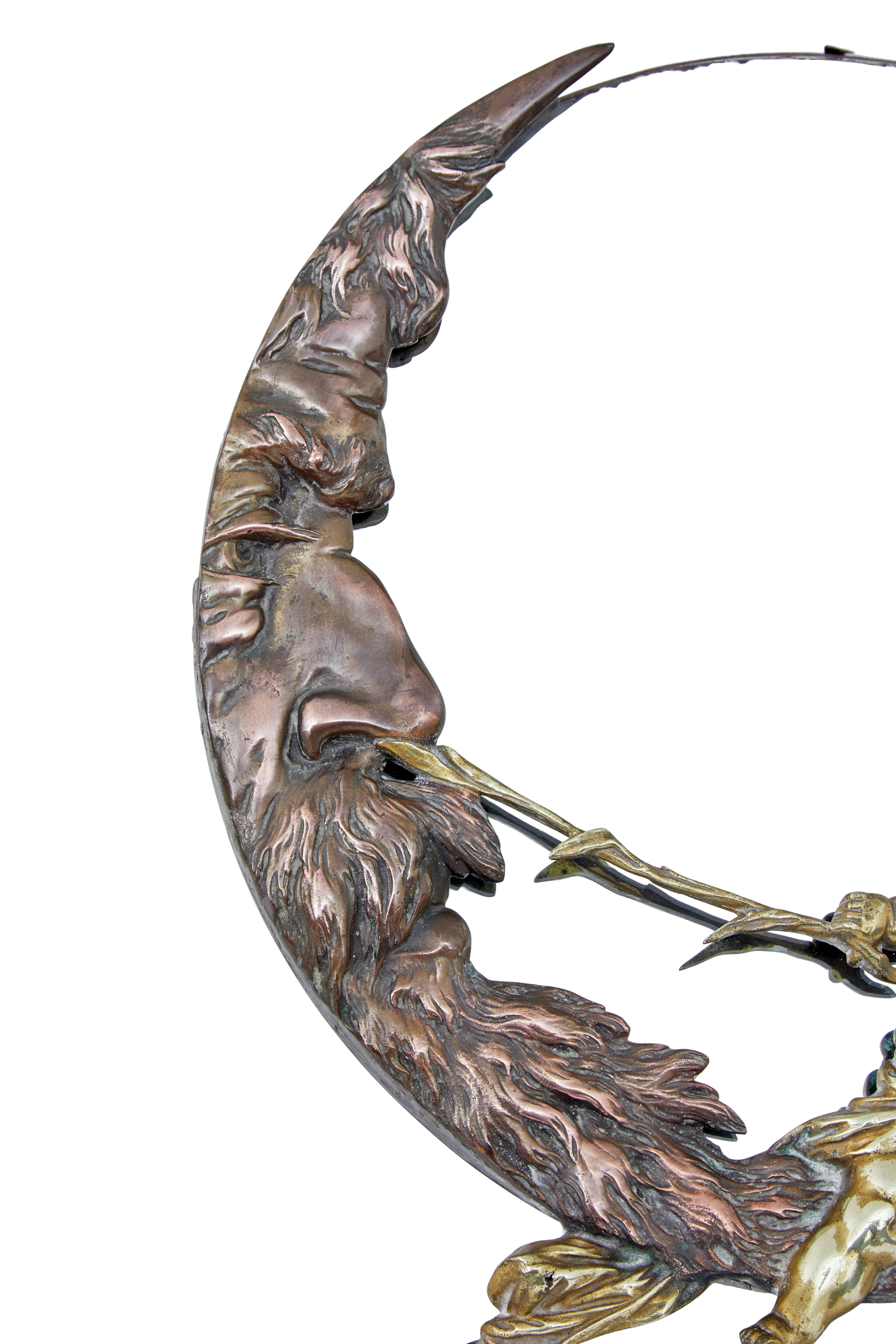 Miroir de table art déco en bronze et laiton circa 1920.

Superbe miroir de table art déco, représentant un chérubin chatouillant le nez d'un visage mythique en forme de croissant.  Miroir circulaire à bord biseauté.

Il est soutenu au revers par un