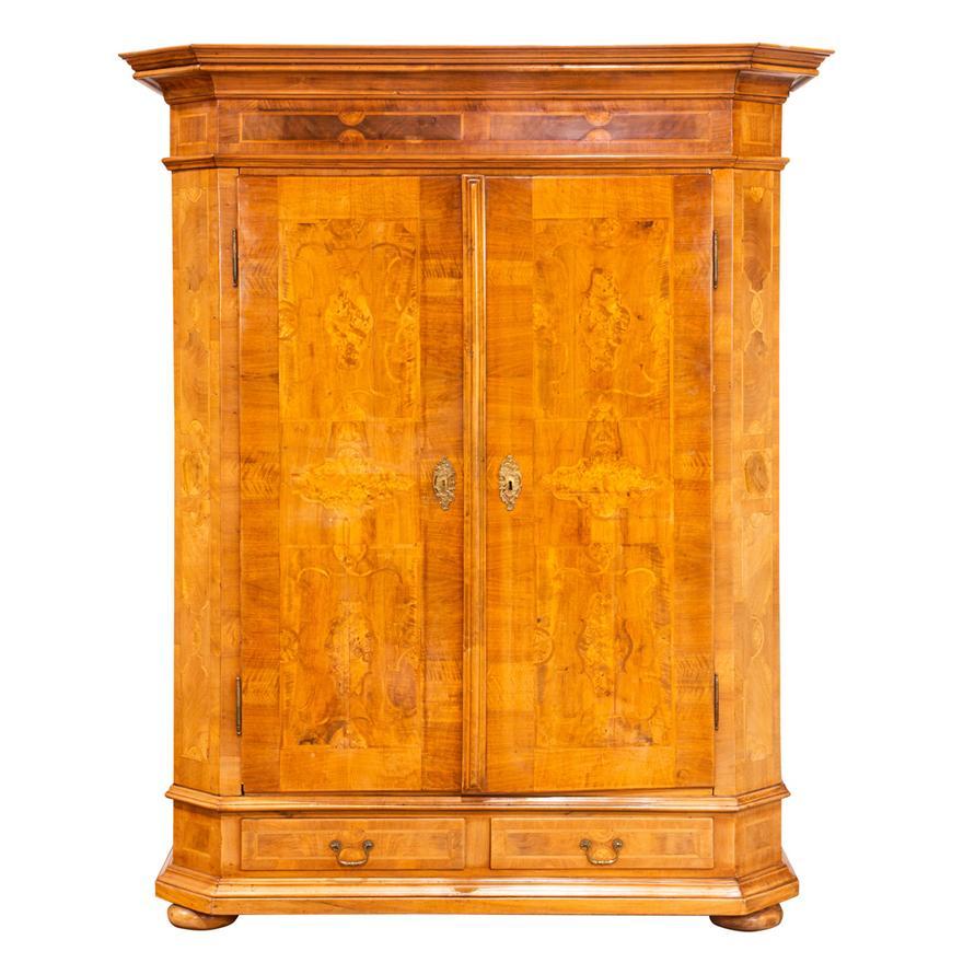 Early 19th Century (Circa 1820) burl walnut marquetry decorated armoire, the two door case with burlwood marquetry above two drawers, camfered corners and rising on compressed ball feet. Interior compartment segmented into two sides with removable,