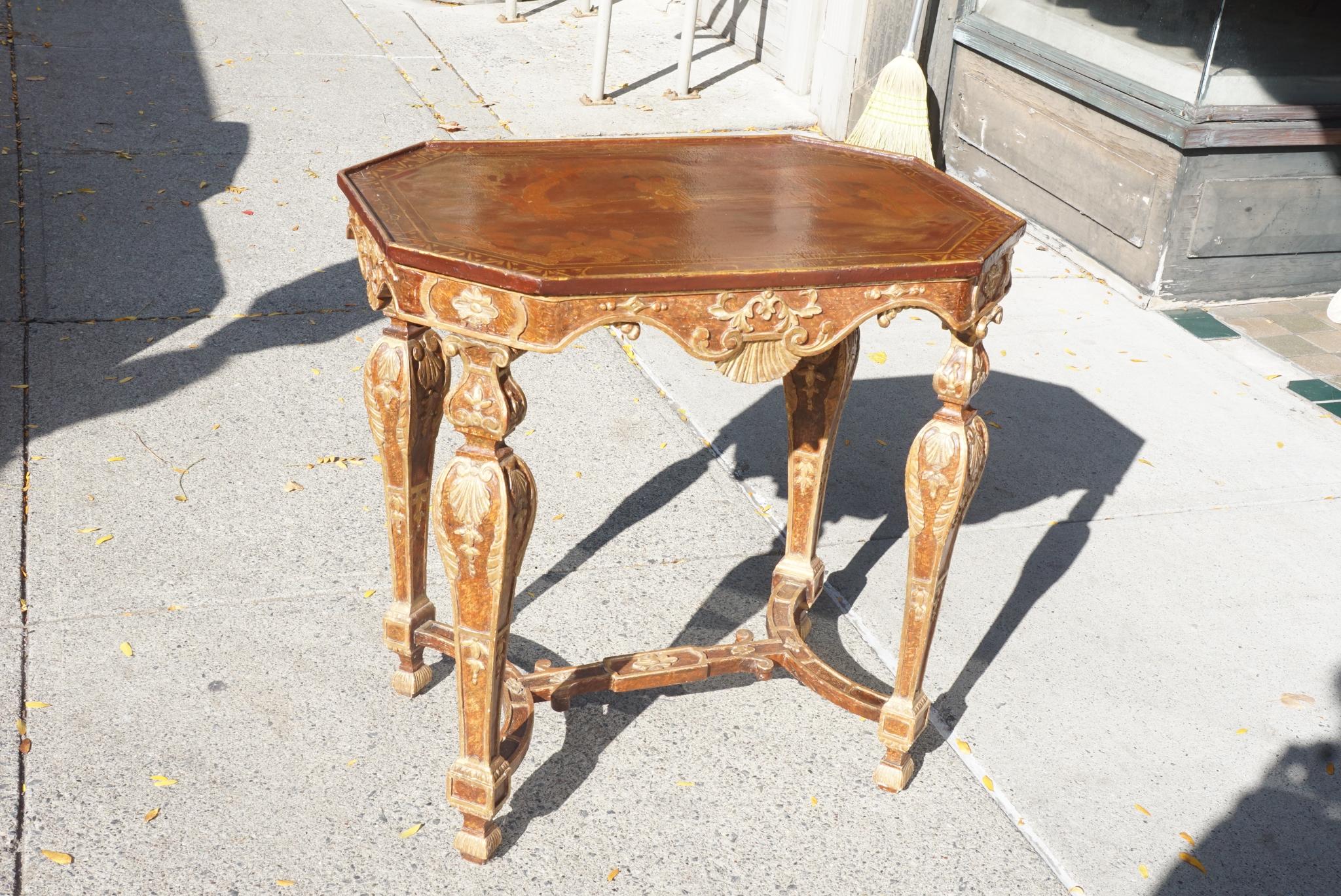 This table crafted in carved painted and gilded wood was made in Italy, circa 1700. The style is fully Baroque and at one point may have had a specimen marble top. The present top is from circa 1880-1900 (see last two photos) and is most likely