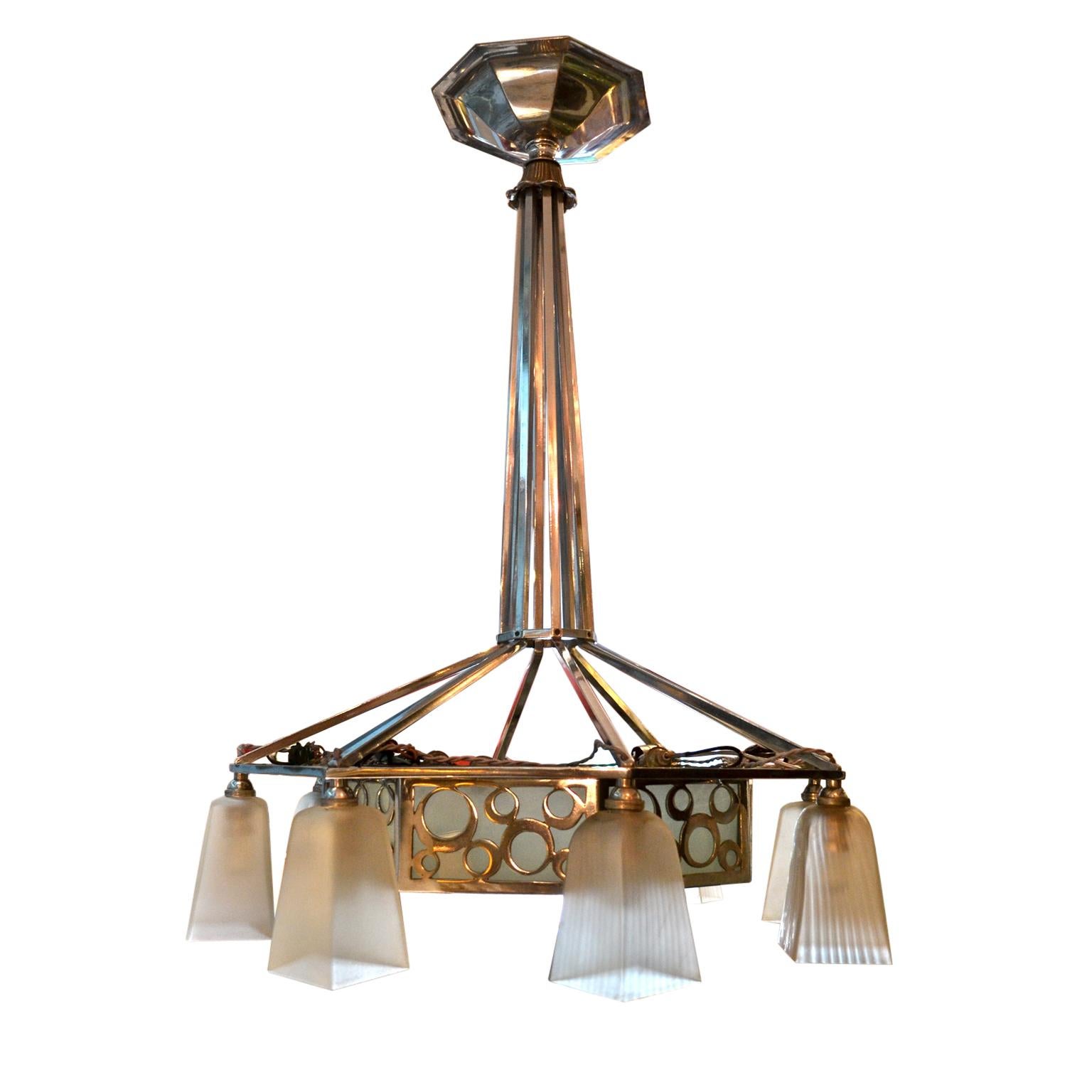 A period Art Deco nickel silver and frosted glass chandelier; eight frosted globes, (slight variation in two globes) are suspended from the lower octagonal ring with ‘bubble’ design open metal work; France circa 1930.
Dimensions: 37?H (94cm) x 28?W
