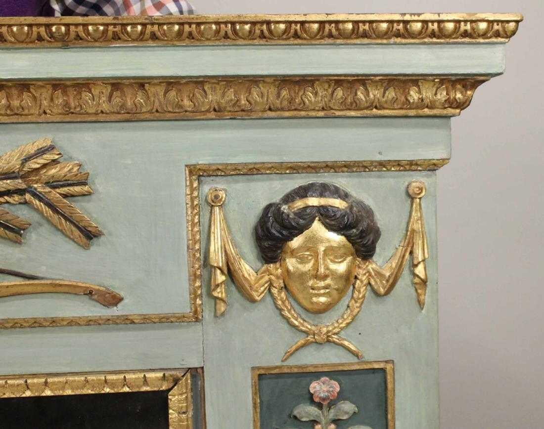 Period Empire painted and giltwood overmantel mirror

Wonderful colors and carved trophy motif of quiver and bow. Swags and neoclassical faces over foliate amphora side panels. Distressed mirror plate.