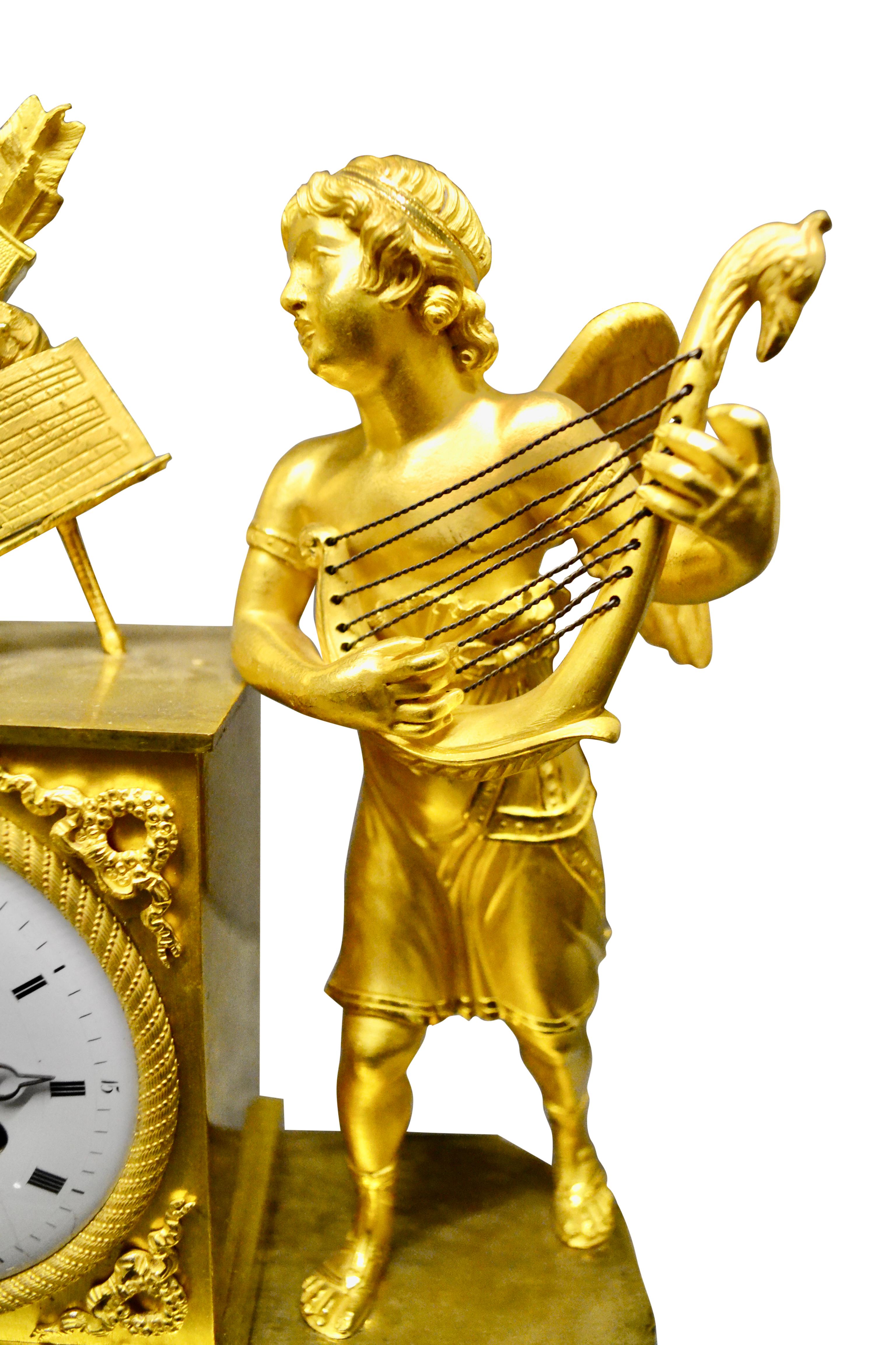 Französische Empire-Manteluhr mit Darstellung eines geflügelten Amors, der eine Laute spielt (Vergoldet) im Angebot