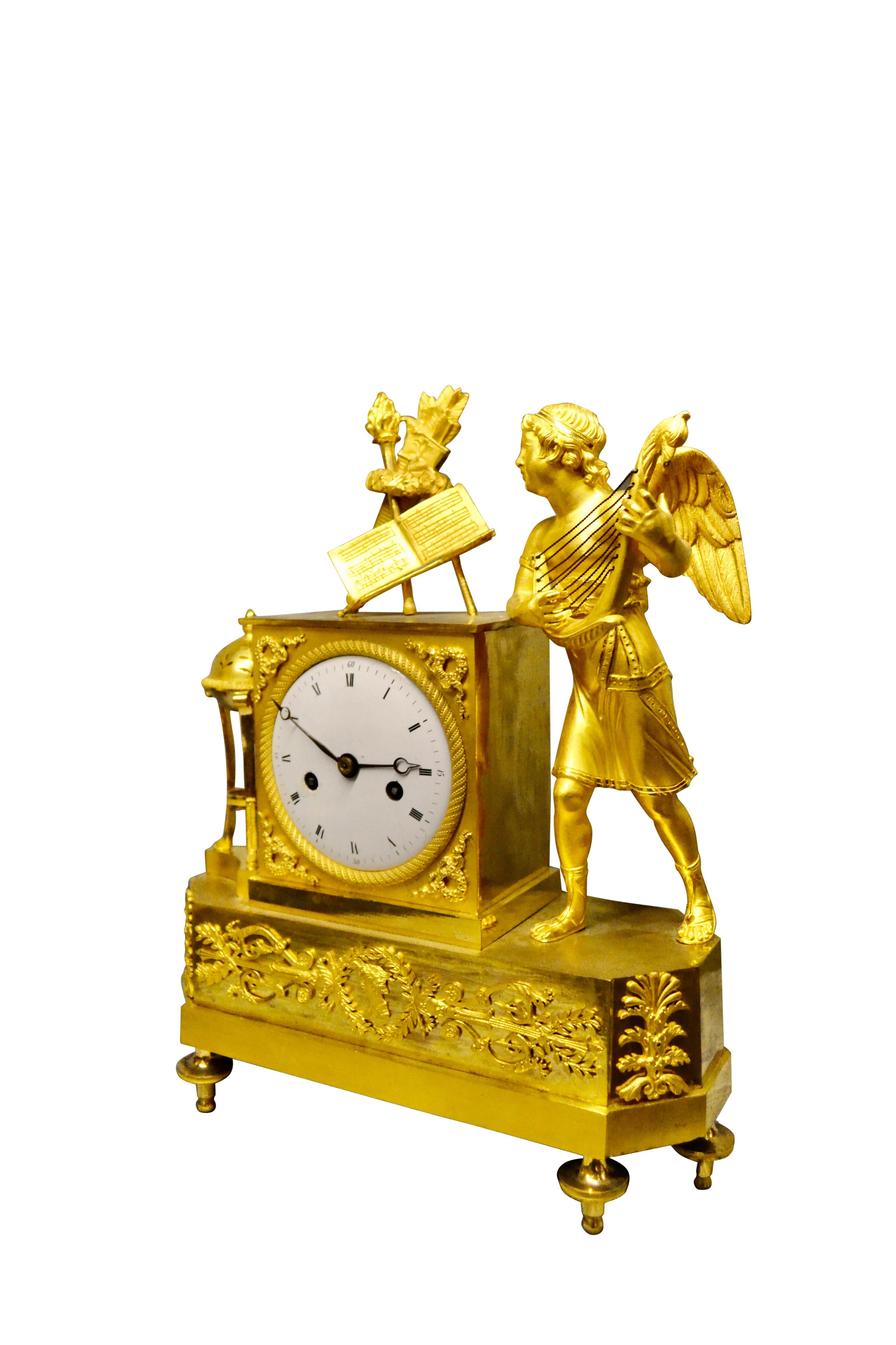 Doré Pendule de cheminée de style Empire français d'époque représentant un Cupidon ailé jouant de la luth en vente
