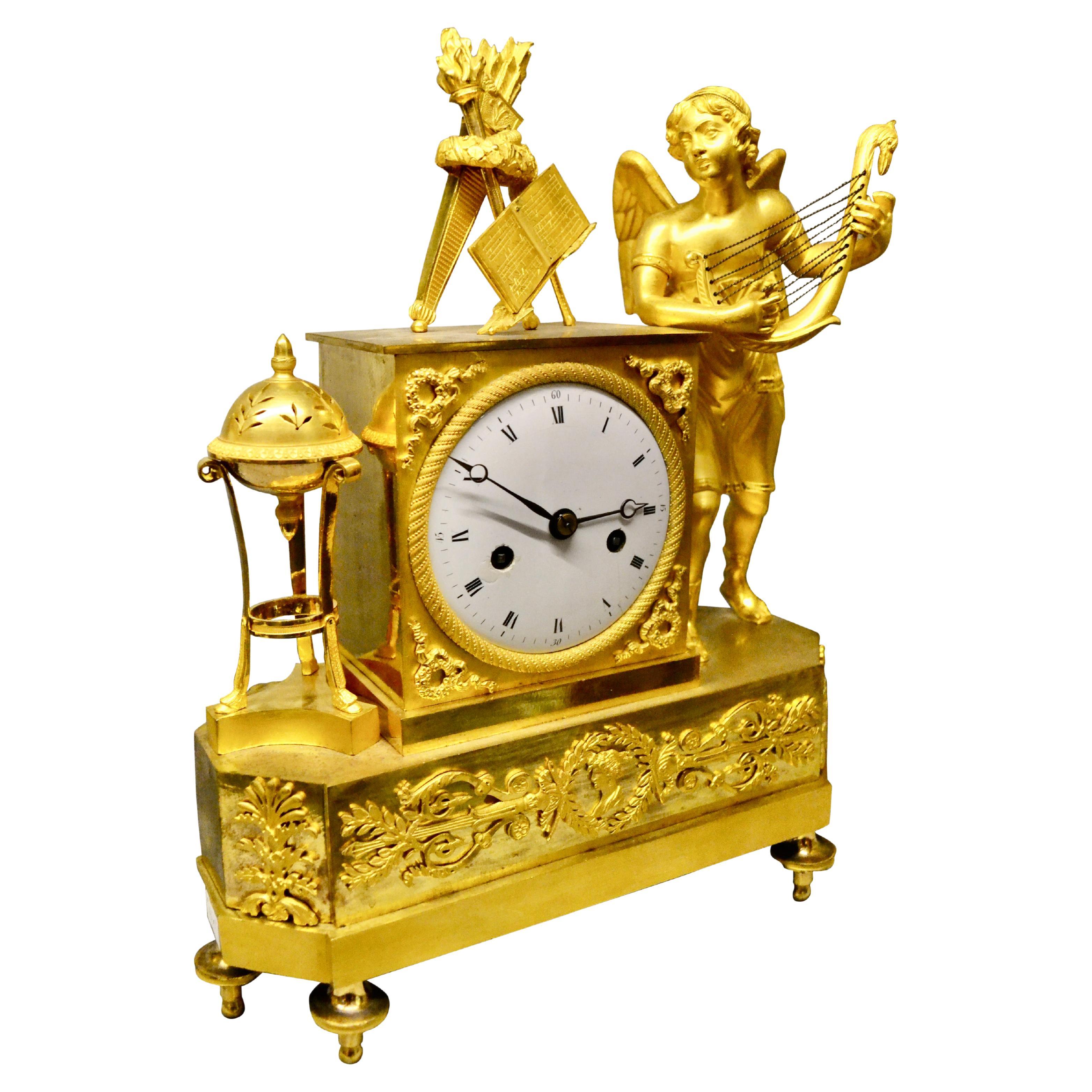Pendule de cheminée de style Empire français d'époque représentant un Cupidon ailé jouant de la luth en vente