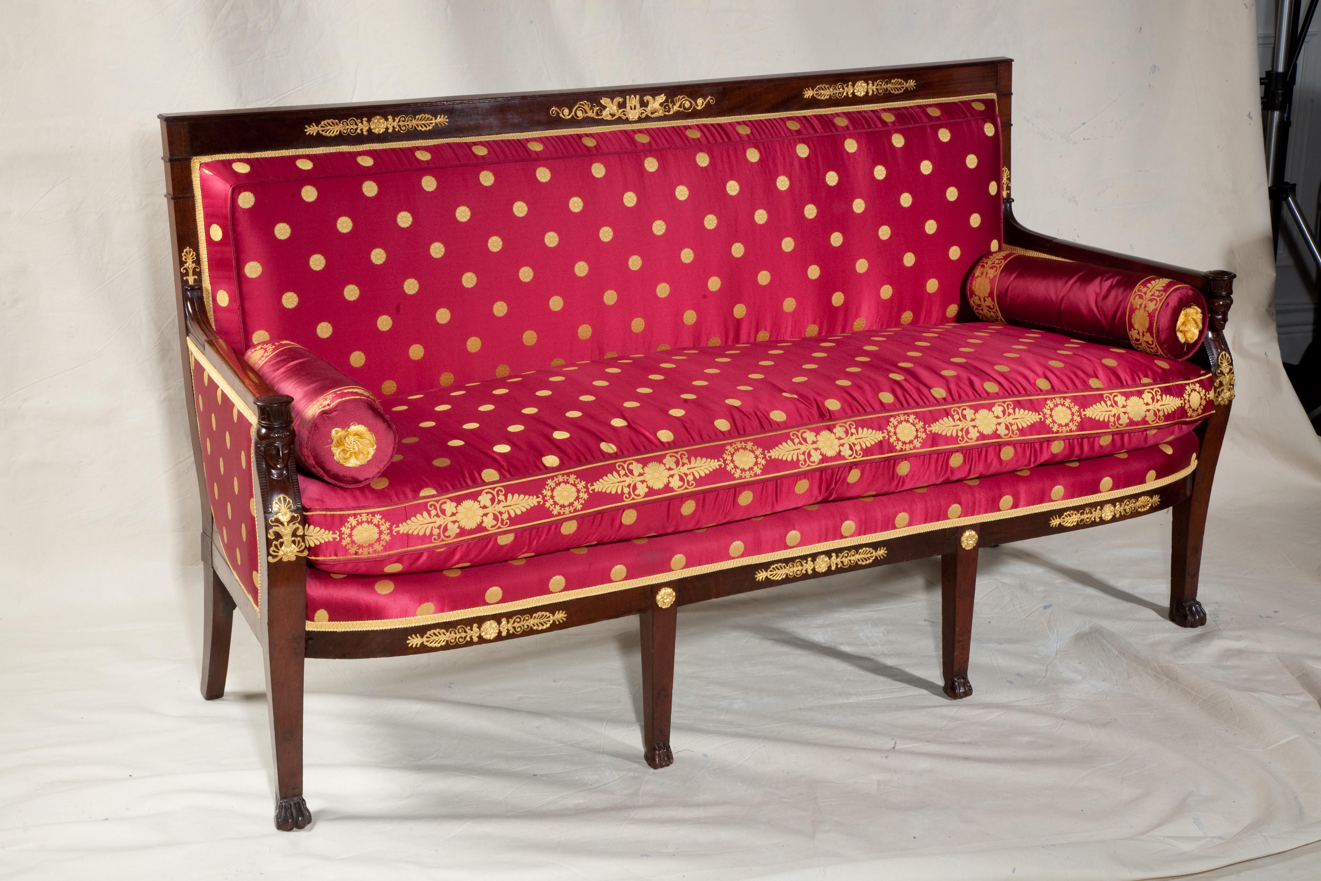 French empire mahogany sofa or settee with gilt bronze mounts and Empire style cerise silk upholstery; attributed by Christies to George Jacob.