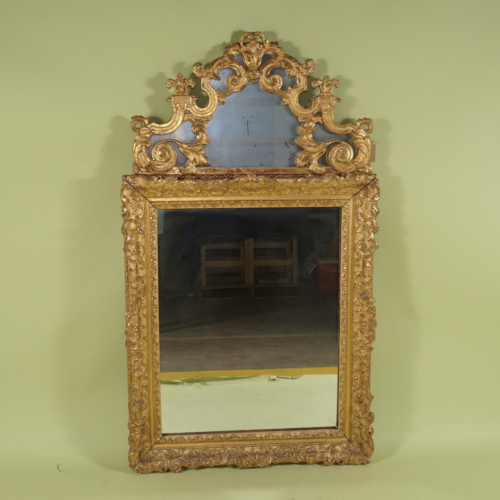 This fine frame from the French Regence period 1715 to 1723 to perhaps 50 years after that exact date is made completely of carved wood that has been gessoed and beautifully water gilded. Originally a frame and then sometime in the late 19th to