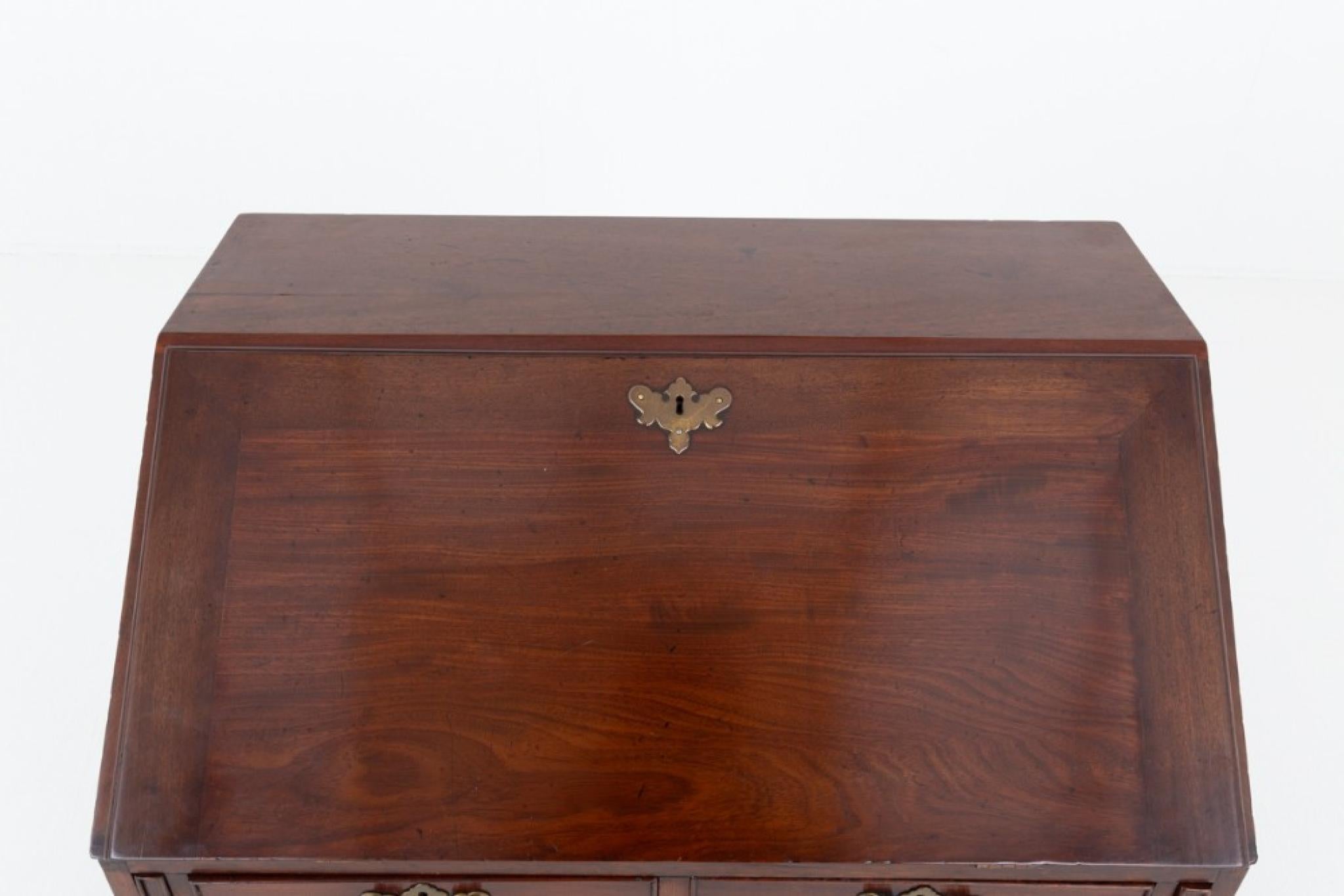 Petite Georgian mahogany bureau.
Period Georgian desk
This petite bureau stands upon shaped bracket feet
Having an arrangement of 2 over 3 oak lined drawers with decorative plate handles and escutcheons 
Will ship to anywhere in the world -