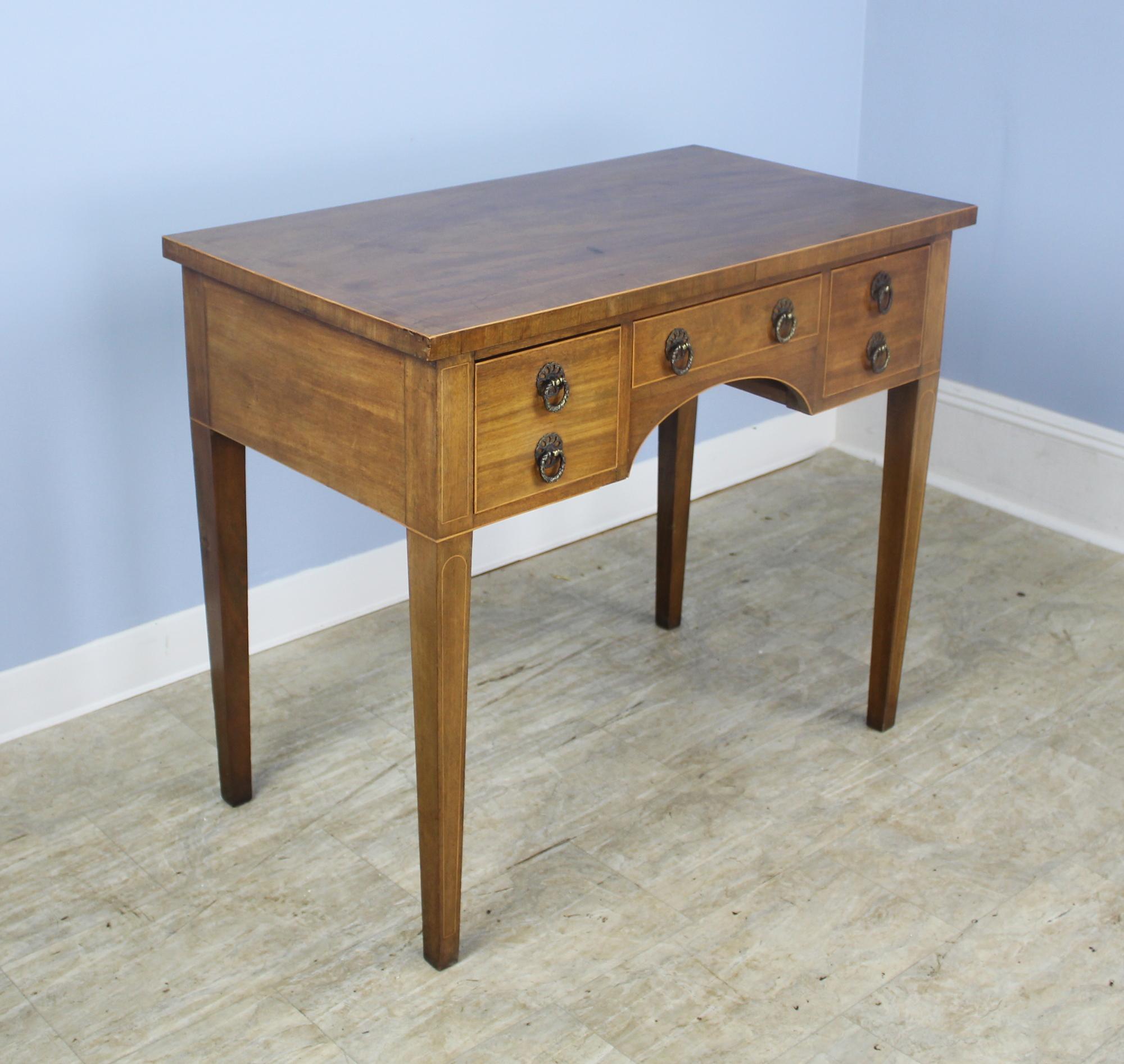 A lovely antique Georgian mahogany lowboy from England. Very simple and elegant. Note the attractive inlay on the legs and top and the crossbanded edge on the top. The mahogany is a beautiful warm color with a pretty grain. Makes a suitable lamp