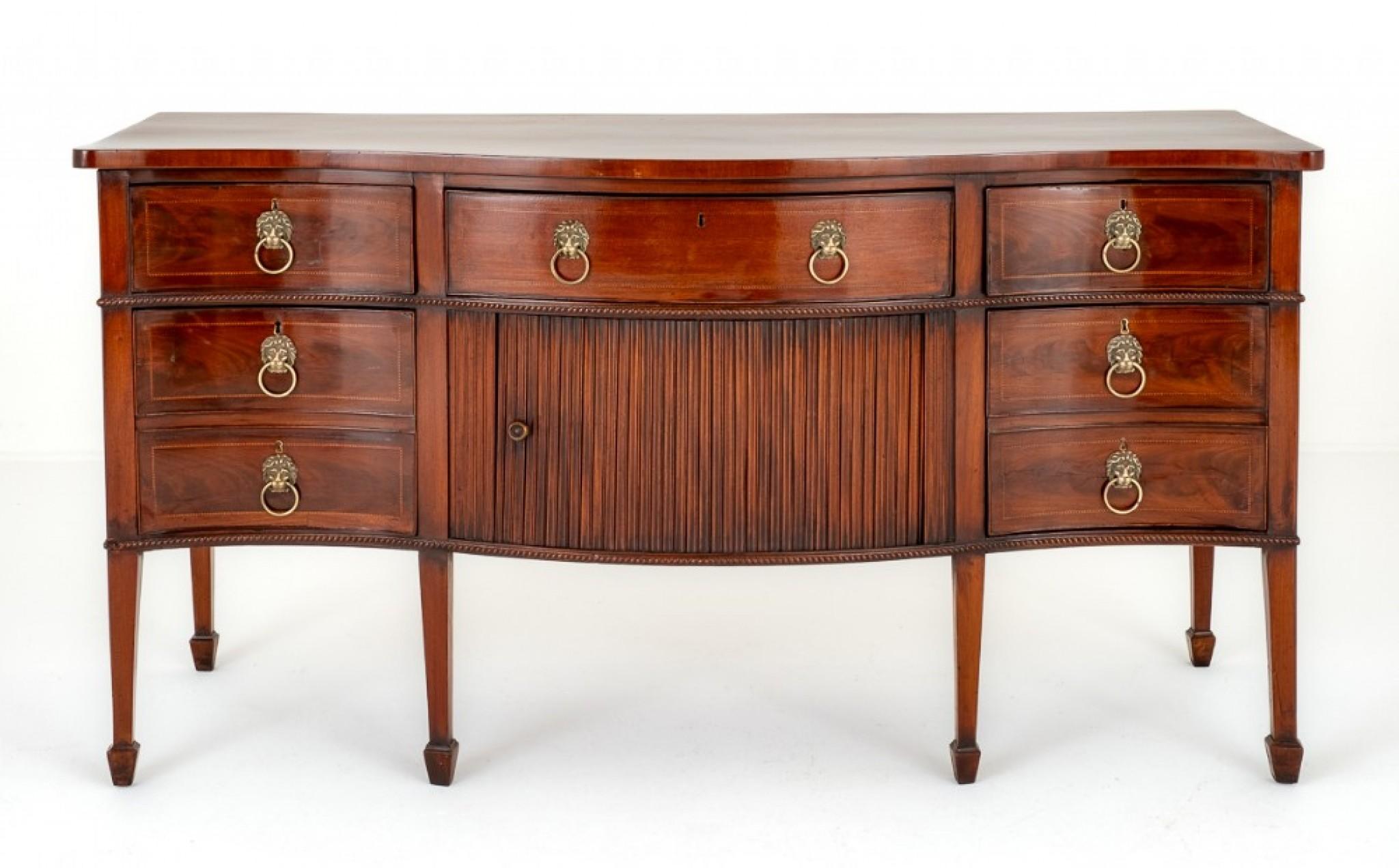 Good Georgian Mahogany Serpentine Sideboard.
This Sideboard Stands Upon Tapered Legs with Spade Feet.
Circa 1800
Having an Arrangement of 5 Oak Lined Drawers.
Each Drawer Having Chequered Inlays and Impressive Lions Head Ring Pull Handles.
The