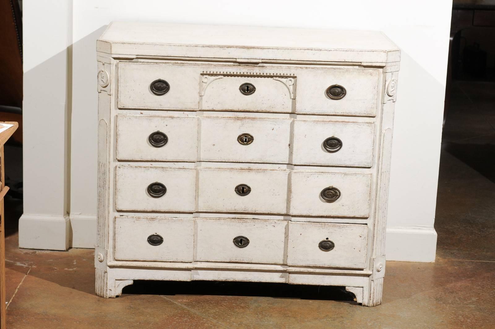 A Swedish period Gustavian breakfront painted four-drawer commode from the late 18th century. This Swedish Gustavian chest features a rectangular top with canted corners in the front, sitting above a breakfront façade. The four hand-cut dovetailed