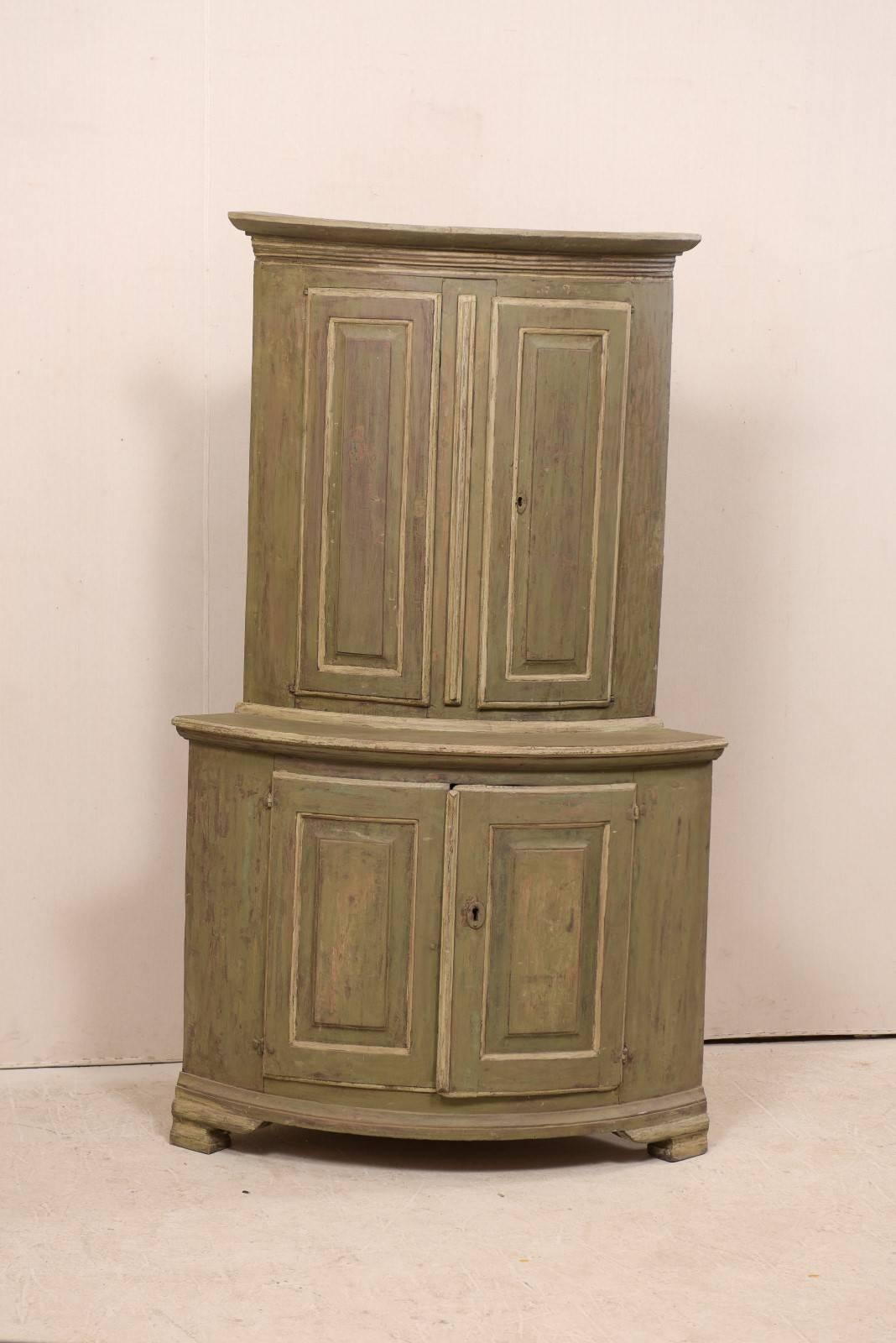 Swedish Period Gustavian painted wood corner cabinet, circa 1770-1780. This Swedish late 18th century antique corner cabinet features a curvy bow front shape, with recessed upper cabinet and raised on bracket feet. There are two upper doors over two