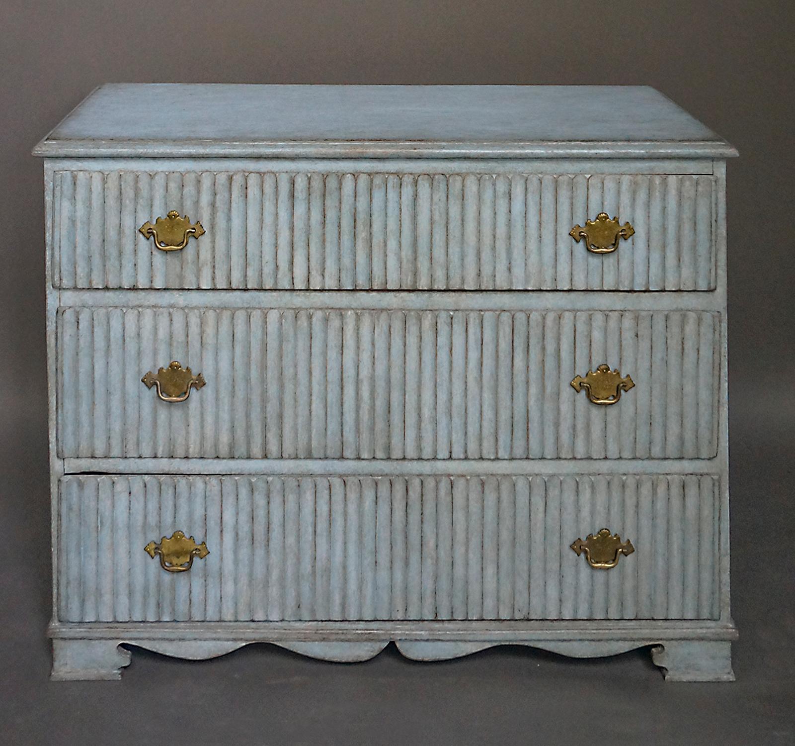 Gustavian chest of drawers, Sweden, circa 1810, with original blue painted surface. The fronts of the dovetailed drawers have strong vertical reeding and original brass hardware. Shaped bracket base.