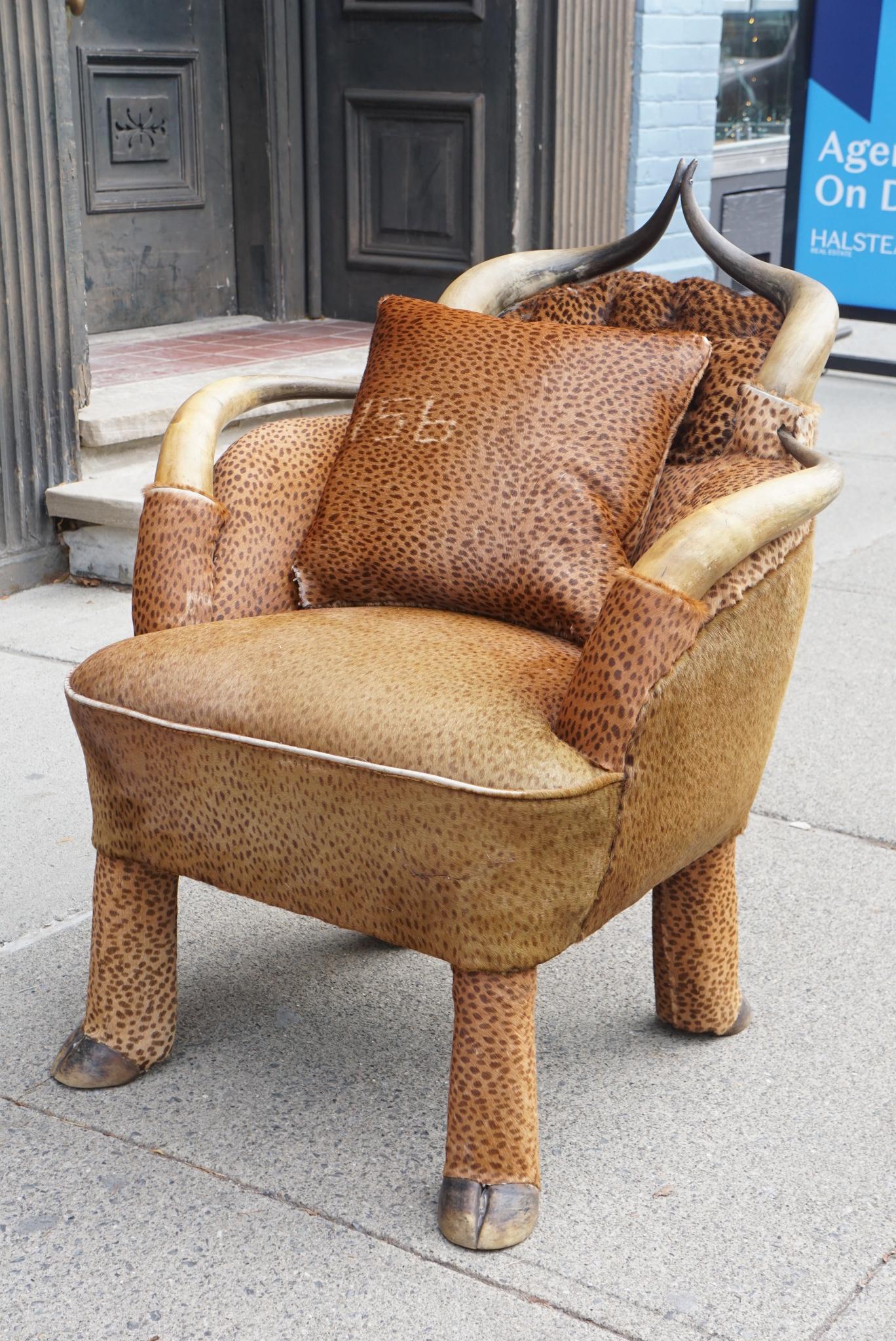 This American chair made circa 1890-1900 is constructed of steer horns with cow hoofs as legs. The chair would have been made for a ranch or camp designed as a retreat from city life for well to do citizens. The new upholstery is in a cheetah