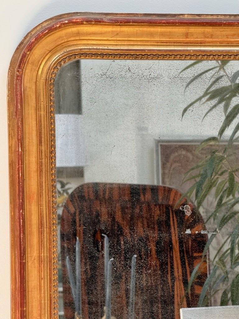 Period Louis-Phillipe arched mirror, mid-19th Century, having original gilding and mirror plate.  The frame with elegant molding and beading.  32” h. x 26.25” w. x 2.25” d.

