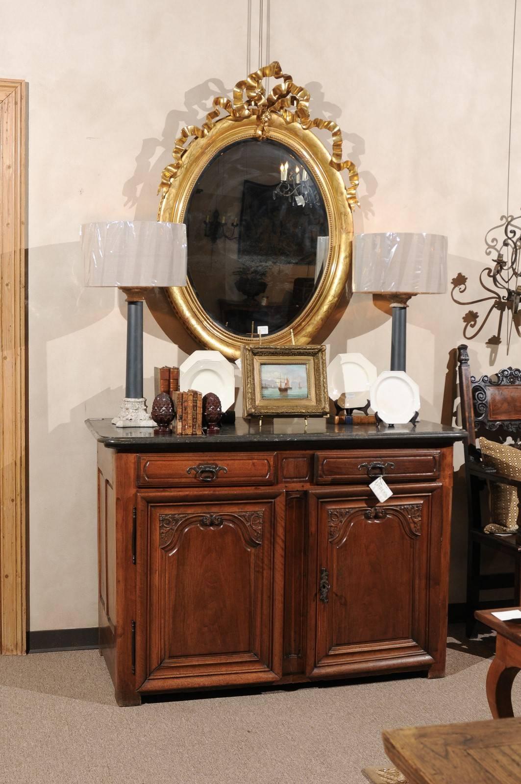 Period Louis XIV walnut buffet with stone top

Everything about this buffet is as it should be. The carving, the paneling on the sides and doors, and the patina are all wonderful. The stone top is dotted with inclusions like fossils and the