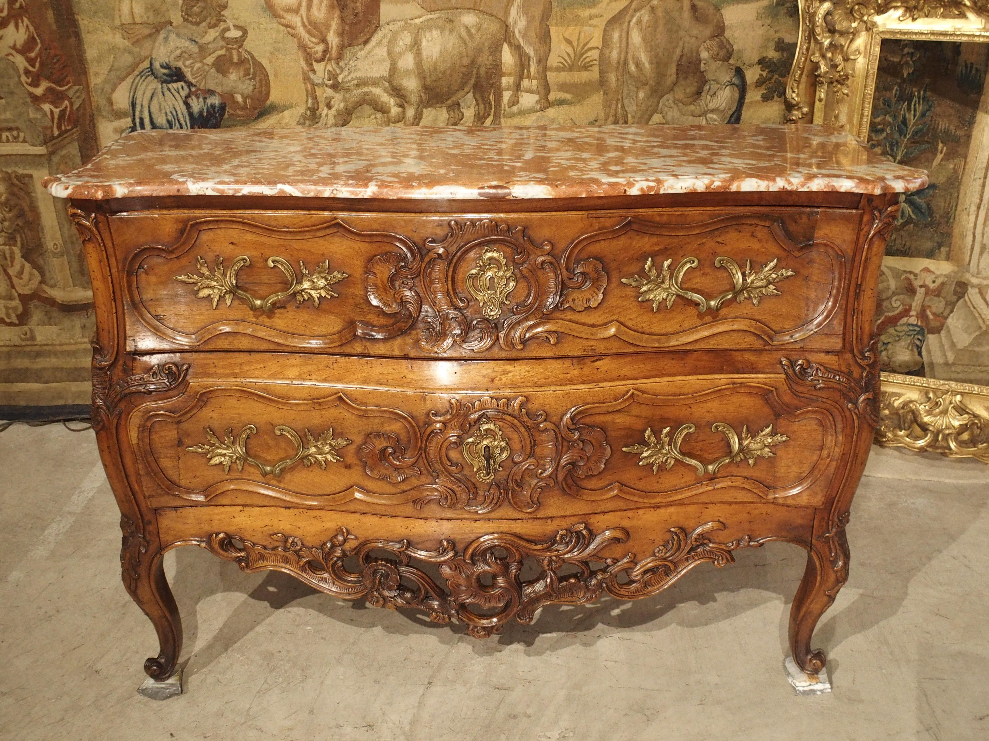 This richly decorated two-drawer commode in walnut wood, is from Nimes, France, and was created, circa 1740. Furniture makers from Nimes and their neighbors in Arles, used the finest materials and paid close attention to line and form. Commodes, or