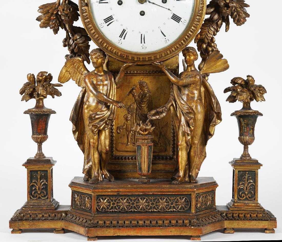 Large Johann Sachs Austrian clock in large carved wood housing with figures, flanked by decorative flower filled urns, polychromed and gilt. Carved laurel wreath swags around the top and sides with fruit and berries, great details. 

A figure of