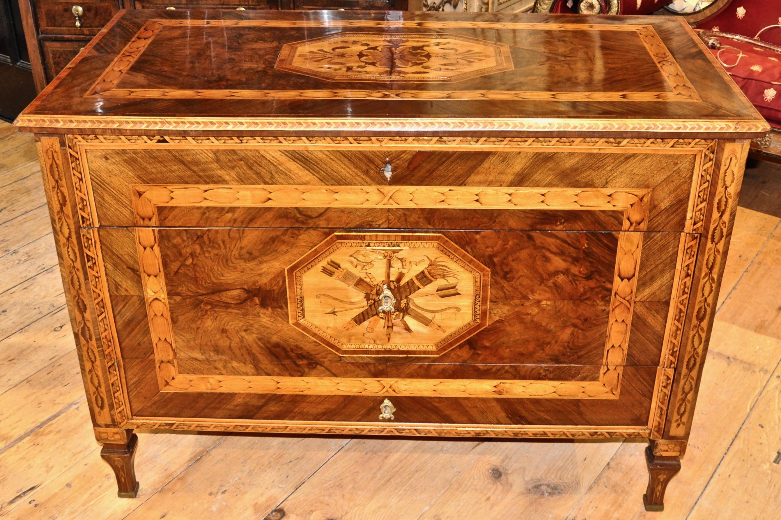 Period Italian or Milan three-drawer marquetry chest of drawers or commode.

--Beautiful original marquetry work of neoclassical trophy. 
--Laurel leaf wreath
--Bellflowers etc.