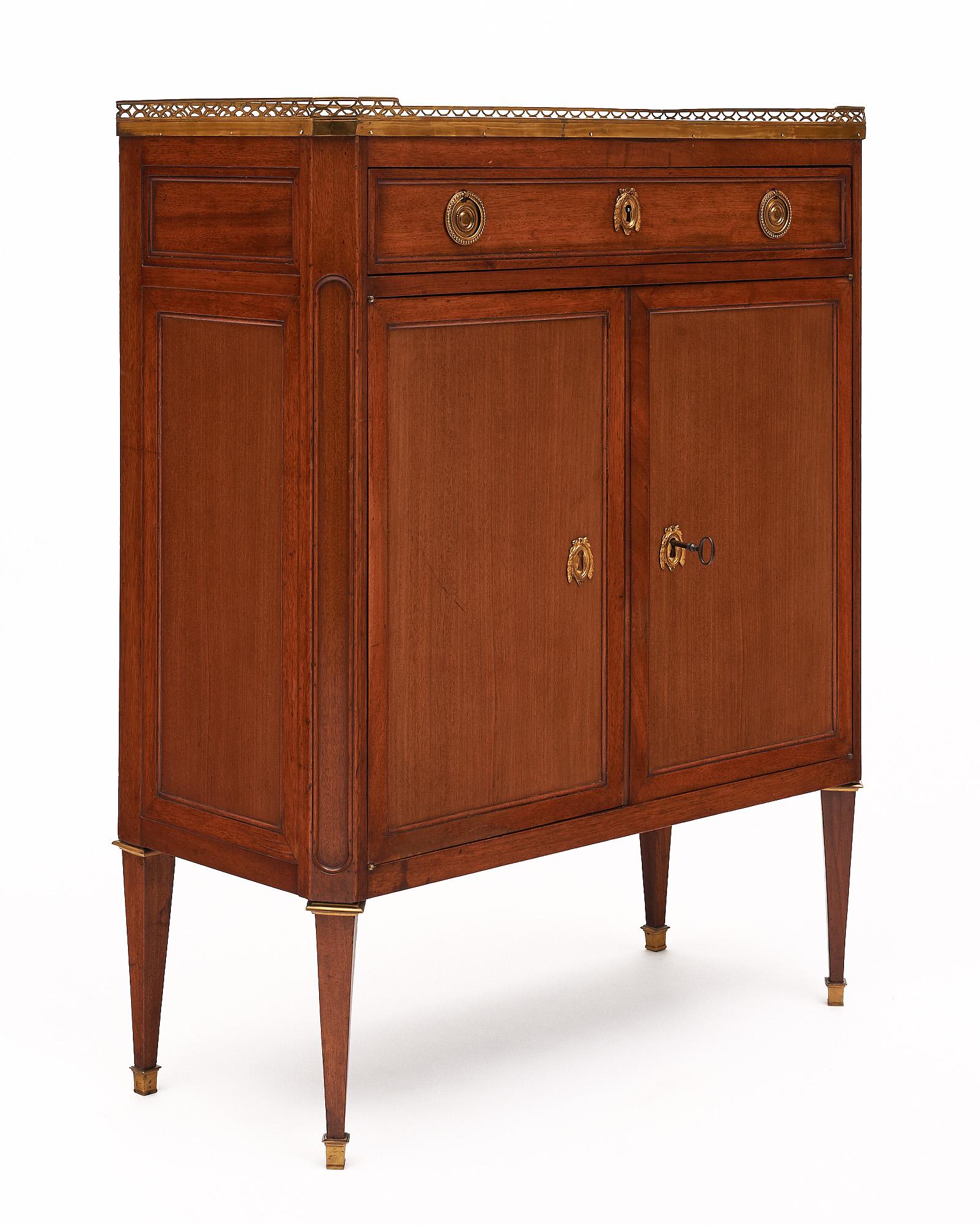 Petite Louis XVI style buffet from France. This piece is made of cherry wood finished in a lustrous French polish. There is a dovetailed drawer above two doors that open to interior shelving. The locks and hardware are all original cast brass. The