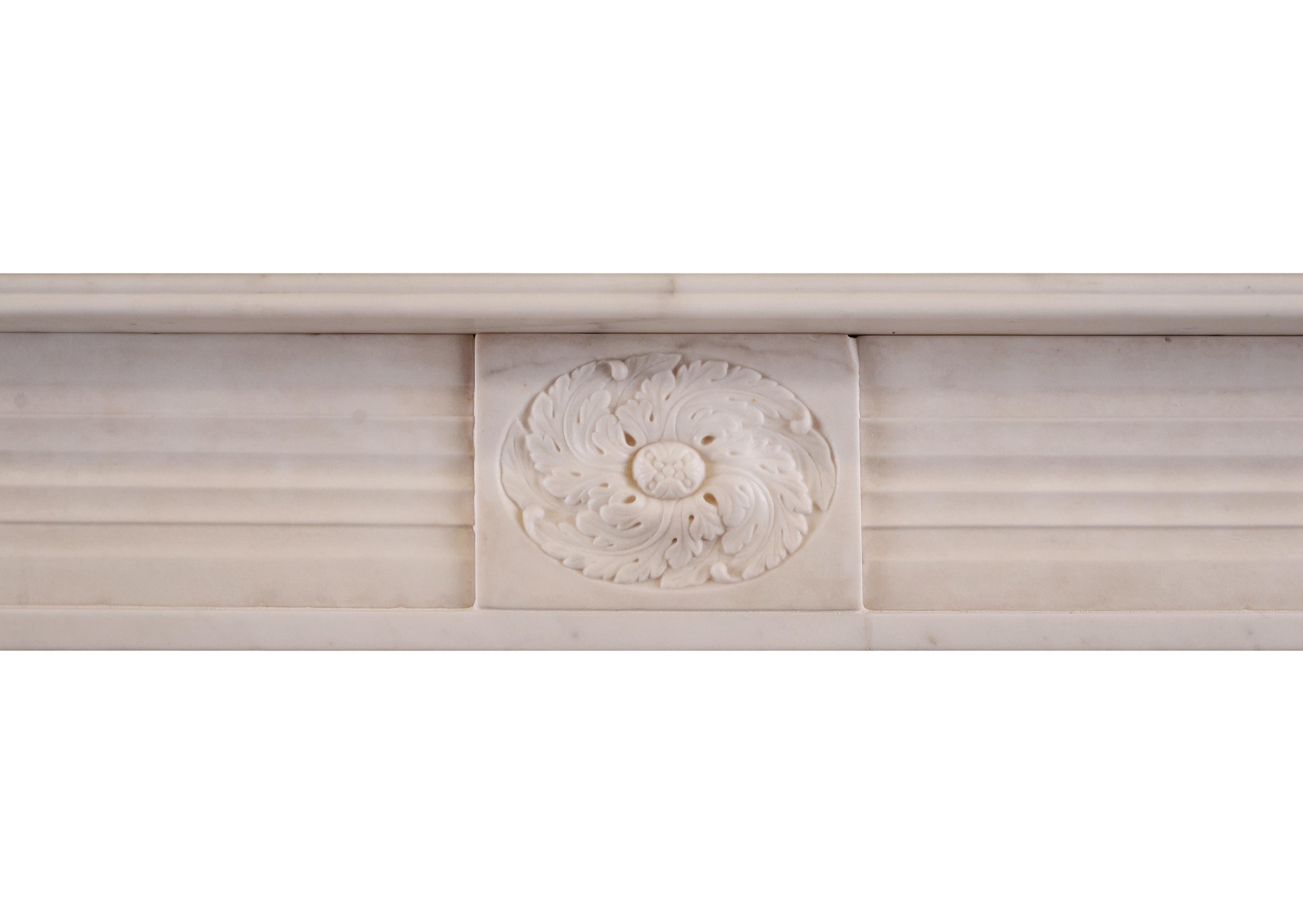 A period English Regency fireplace in statuary marble. The jambs with half rounded reeds surmounted by roundel end blockings. Carved central paterae to frieze, English, circa 1820. One of a very near pair with stock no 3960.

Measurements:
Shelf