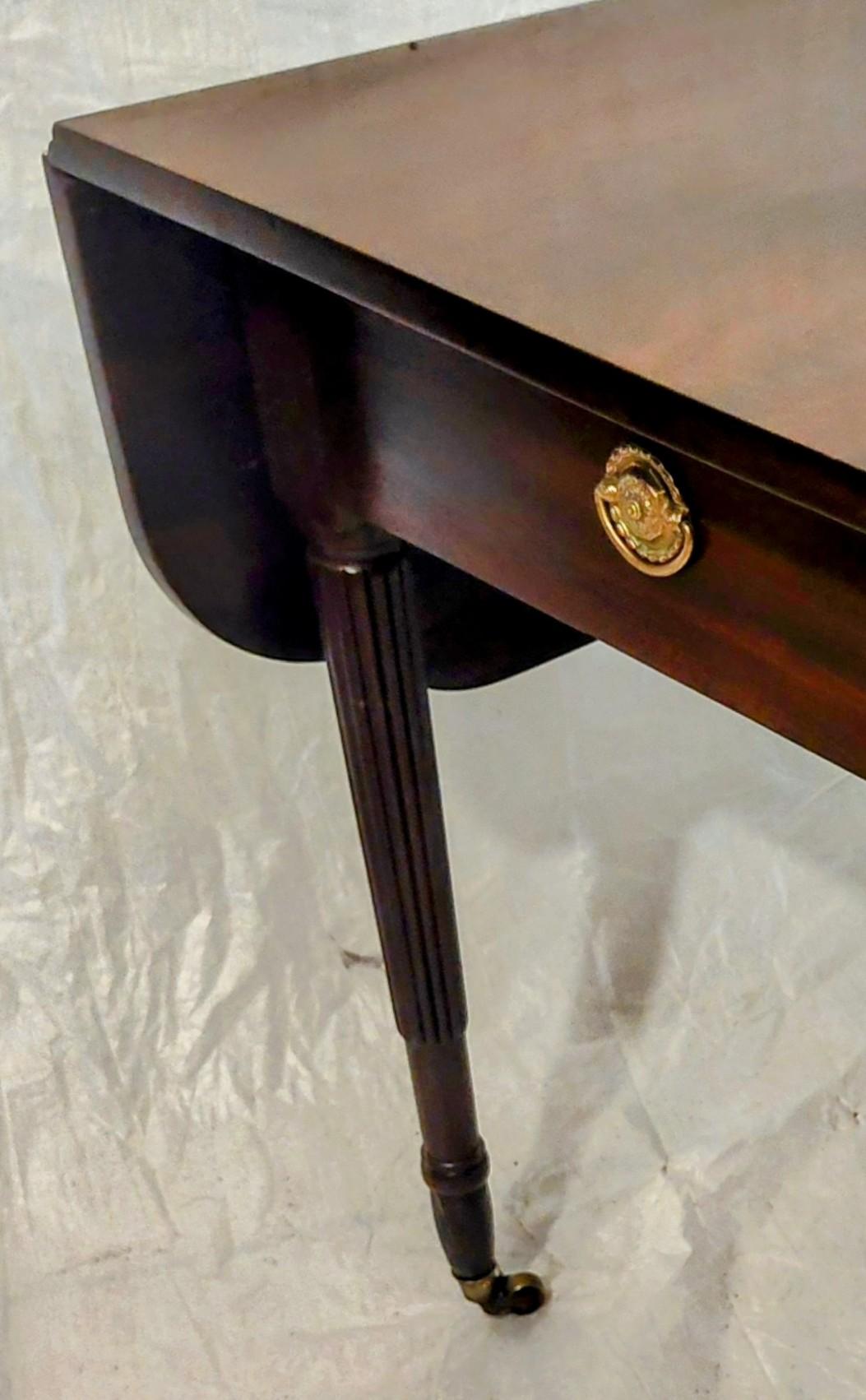 Tavolo d'epoca Sheraton Drop-Leaf/Pembroke. Questo bell'esemplare, probabilmente proveniente da N.Y., è caratterizzato da eleganti gambe con rilievi e dalle rotelle originali in ottone. Dotato di un cassetto sotto un magnifico piano in mogano