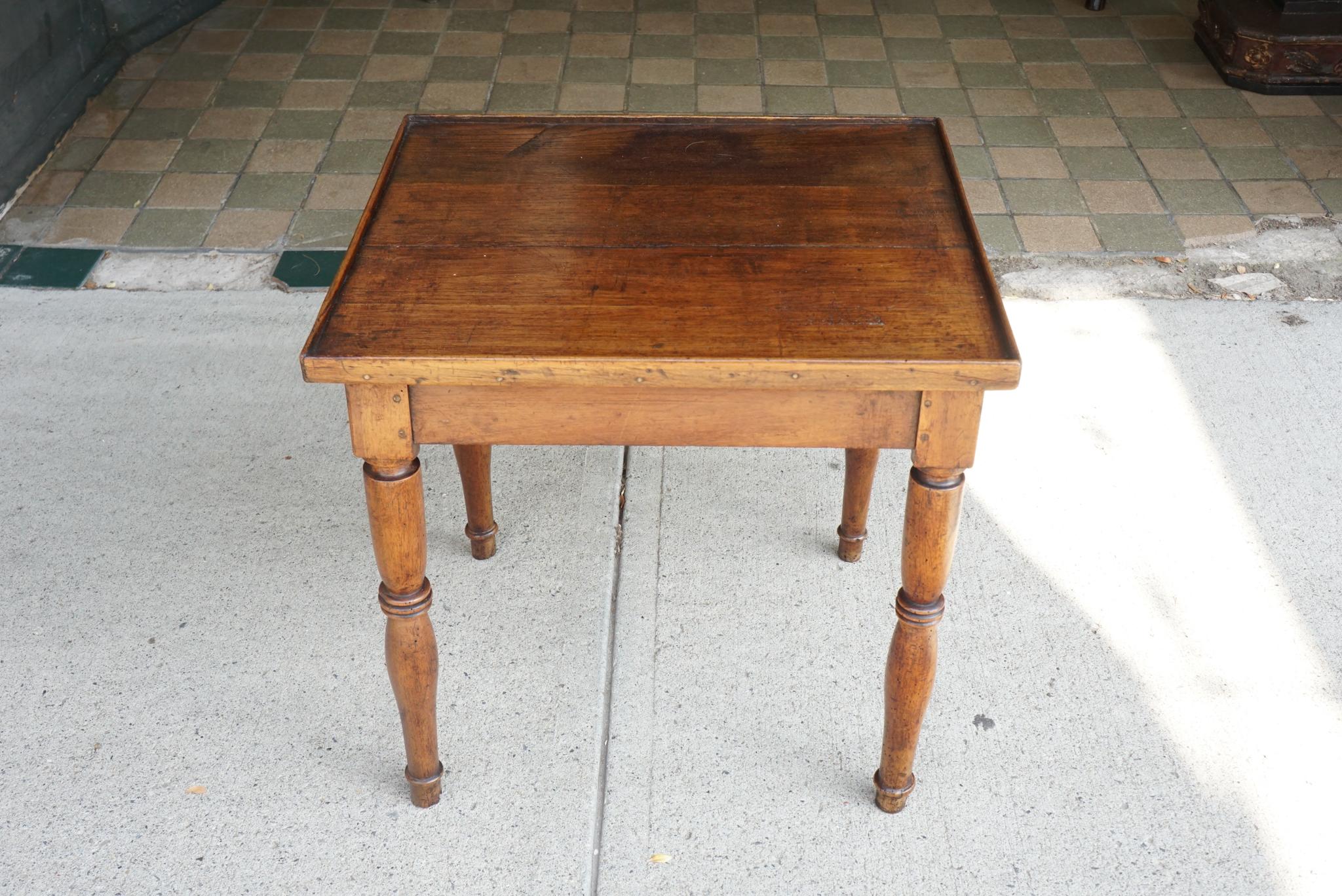 This low small table made in France circa 1800 from walnut and crafted with all peg construction has a nice old surface and well shaped turned legs. Of country manufacture probably it once had a lower tier and short legs under that level. Its