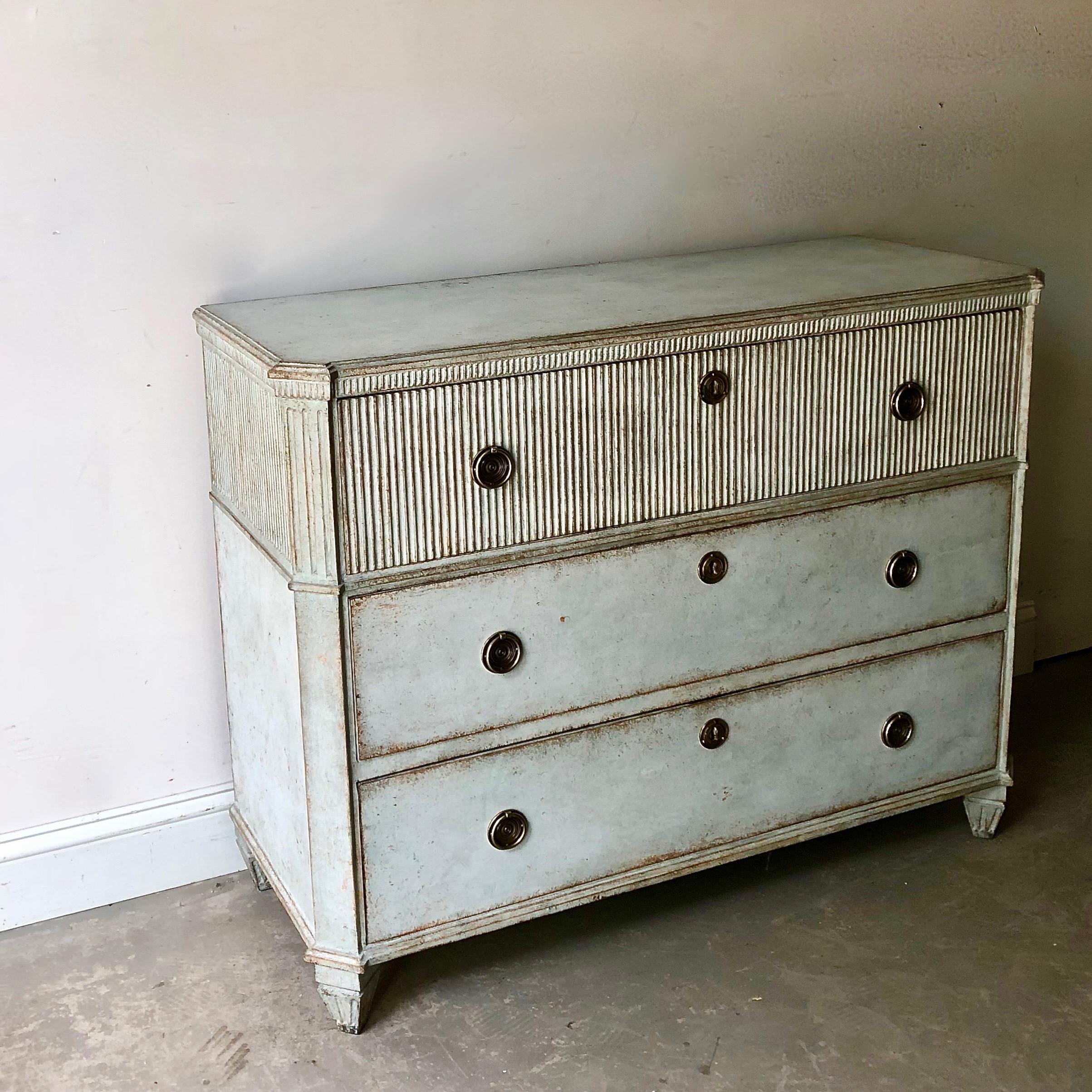 Late Gustavian period chest of drawers with fluting on front of the upper drawer. Shaped top with dental trim under, reeded canted corners and classical feet. Very classical Swedish piece with charming hardwares in pale blue.
Sweden, circa 1810.