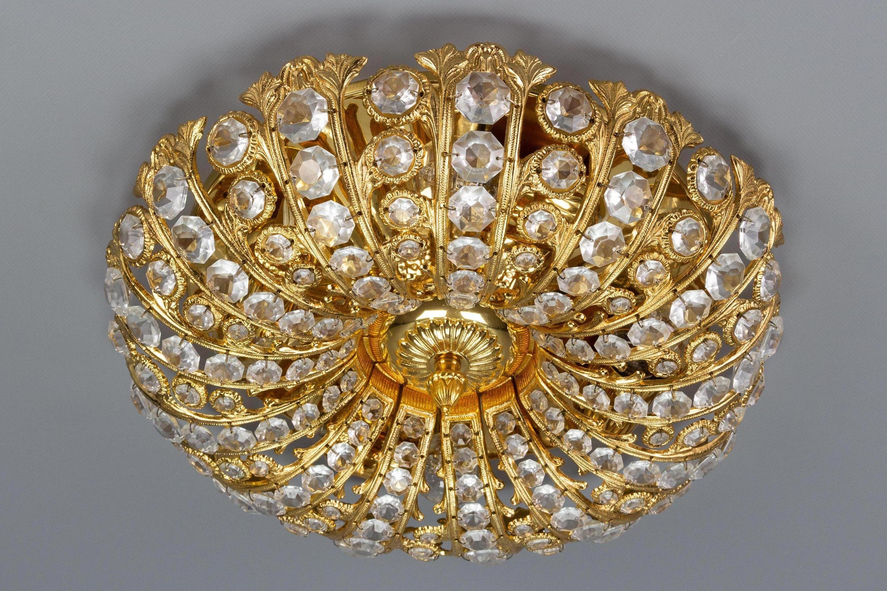 An impressive flush mount or wall lamp by Peris Andreu for S. A. Riper Valencia, Spain, circa the 1970s, featuring a gold-toned metal frame with a Baroque style scroll motif and faceted gem-cut glass prisms, beautifully arranged from smaller to