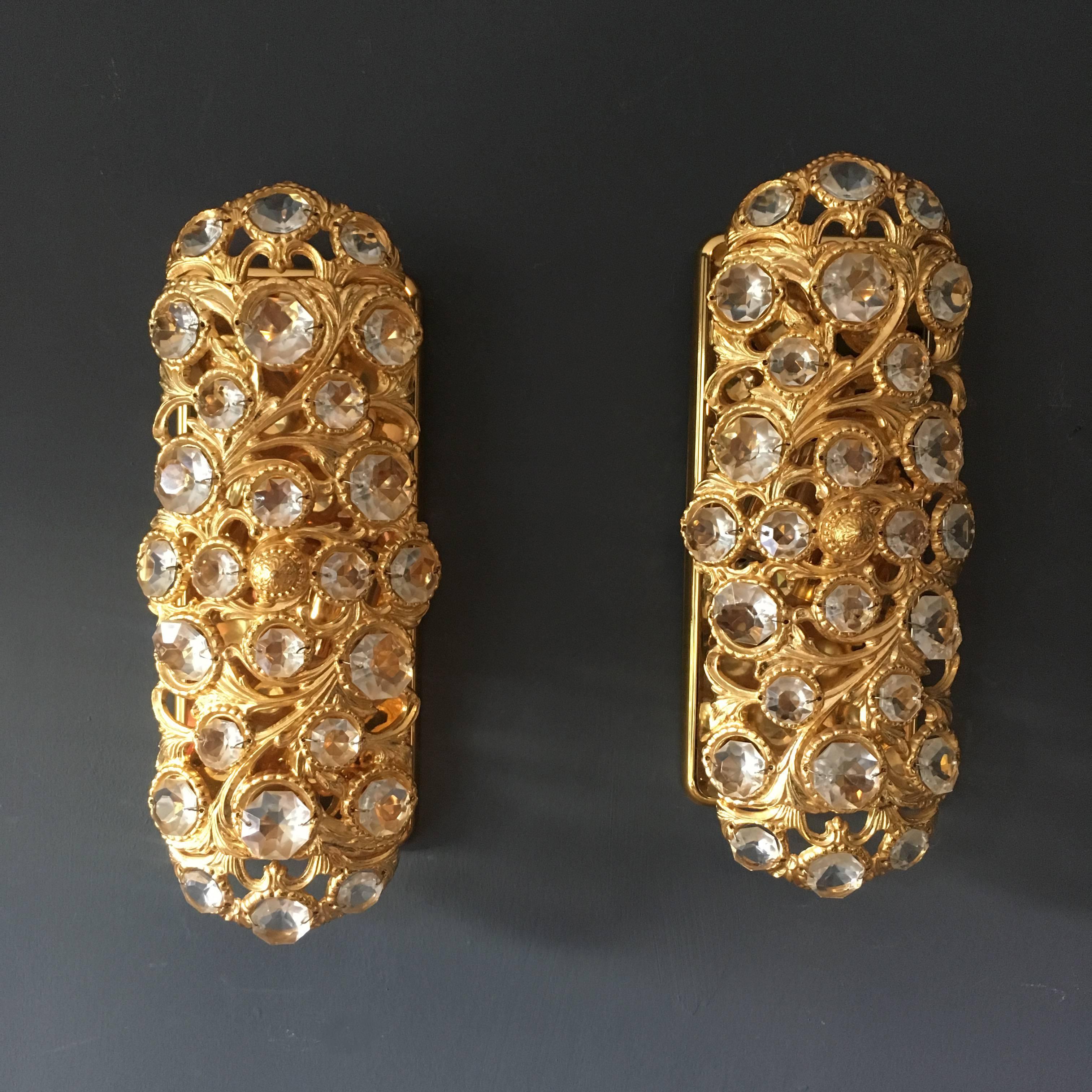 A pair of Peris Andreau gold toned crystal wall lights for S A Riper
Valencia, Spain, circa 1960s.
The lights are in a heavy gold toned metal with reverse prism glass crystals. The gold metalwork is crafted in a Baroque style pattern of swirling