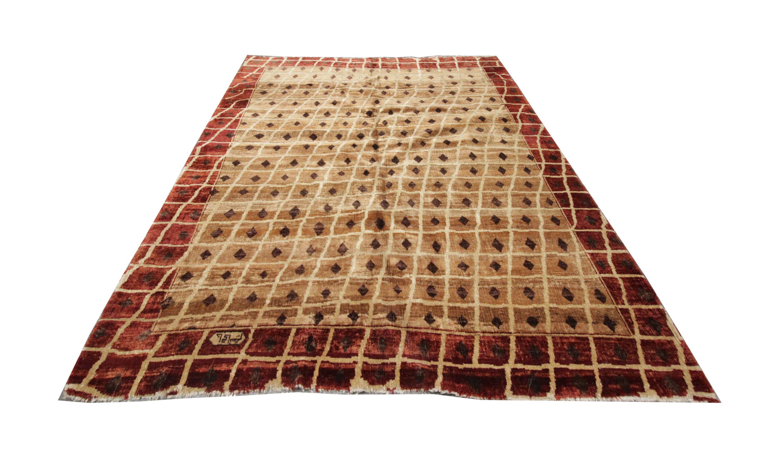 This simple yet grand area rug has been hand-woven with Beige and orange tones. The simple design shows a gridded linear pattern with diamond motifs central to each square. On the border, this pattern continues on a burnt orange background. Unique
