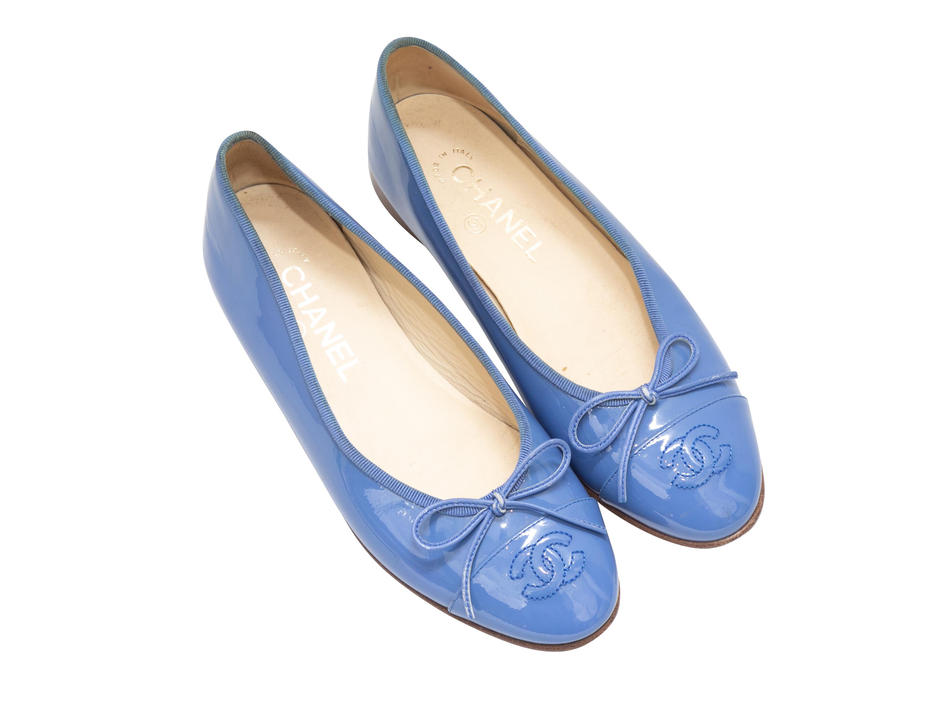 Periwinkle patent leather cap-toe ballet flats by Chanel. CC logo embroidery and bow accents at tops. 3.5