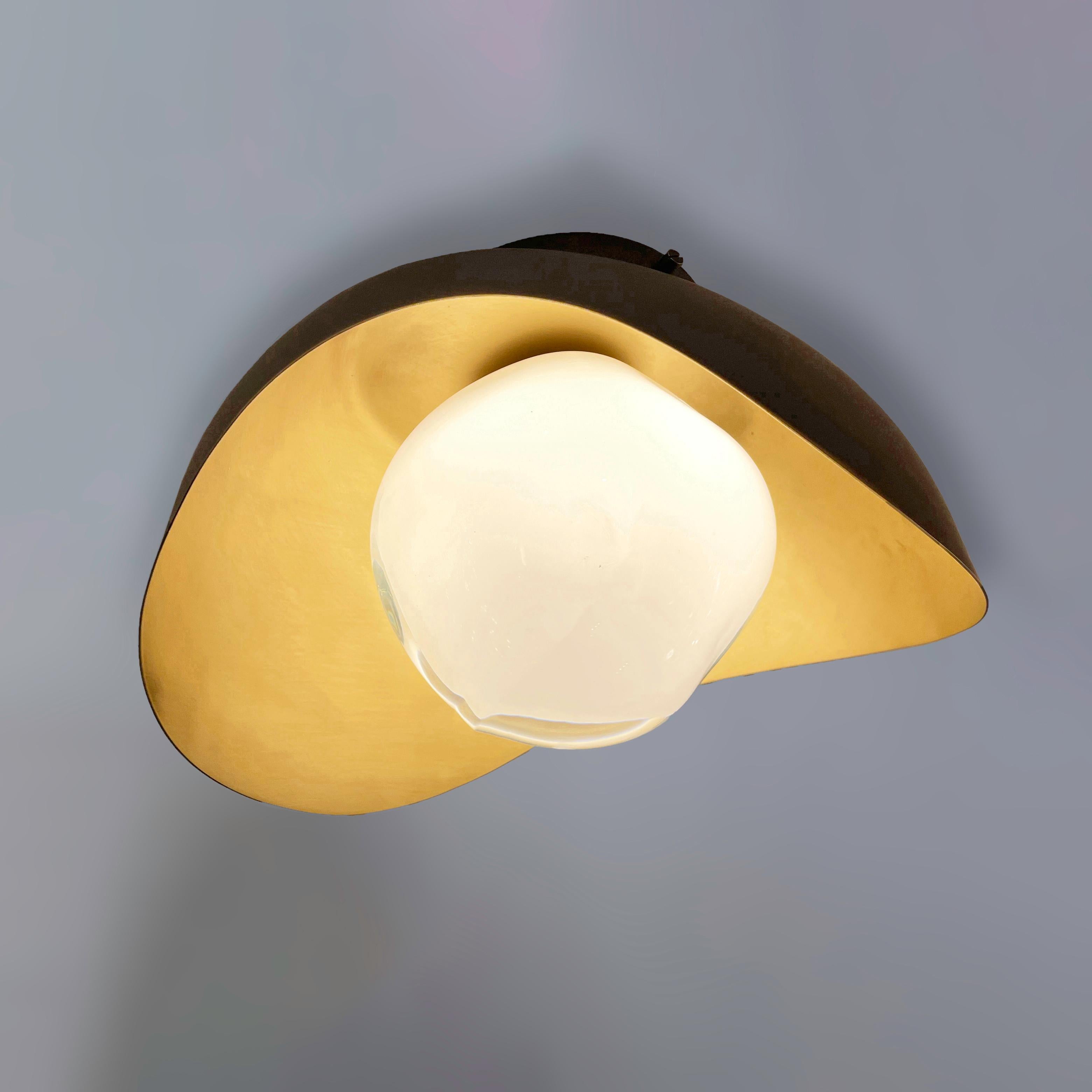 The Perla flushmount features an organic brass shell nestling our Sfera glass handblown in Tuscany. The first images show the fixture with a satin brass interior and Bronzo Nuvolato (bronze) exterior finish-subsequent pictures show it in a selection