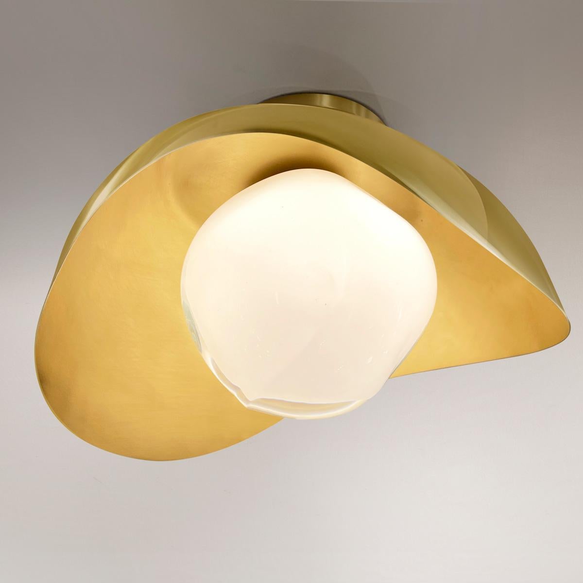 The Perla flushmount features an organic brass shell nestling our Sfera glass handblown in Tuscany. The first images show the fixture with a satin brass interior and polished brass exterior finish-subsequent pictures show it in a selection of